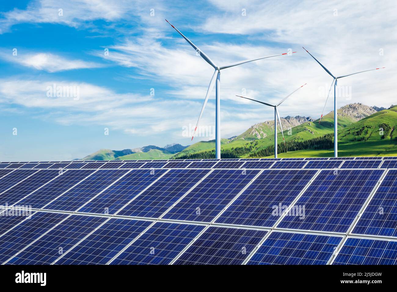 Solar panels and wind turbines with mountain landscape under blue sky ...