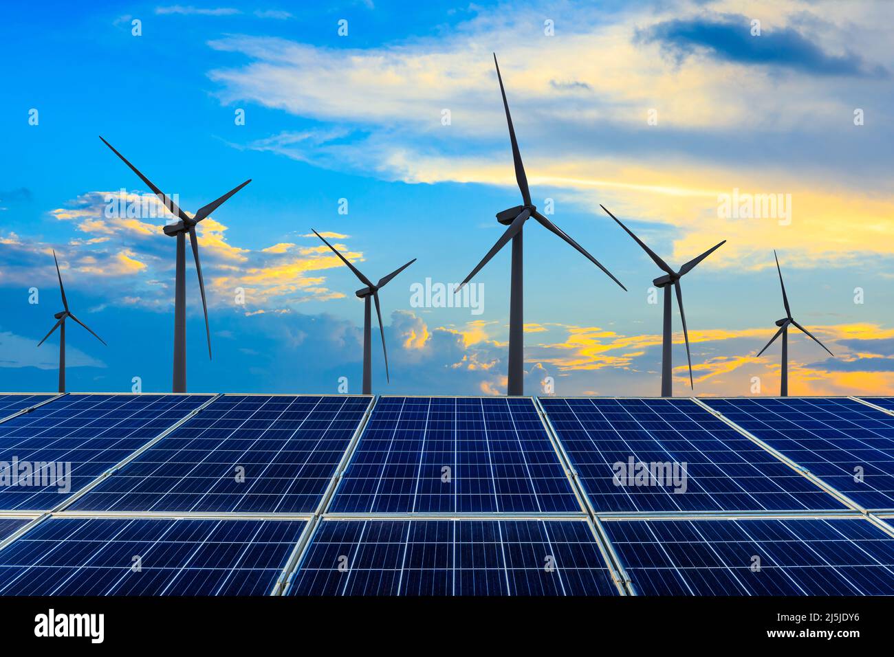 Wind turbines and solar panels at sunset. renewable energy concept ...