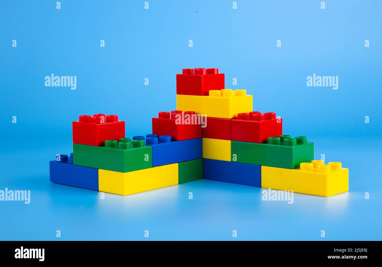 Plastic building blocks on blue background Stock Photo