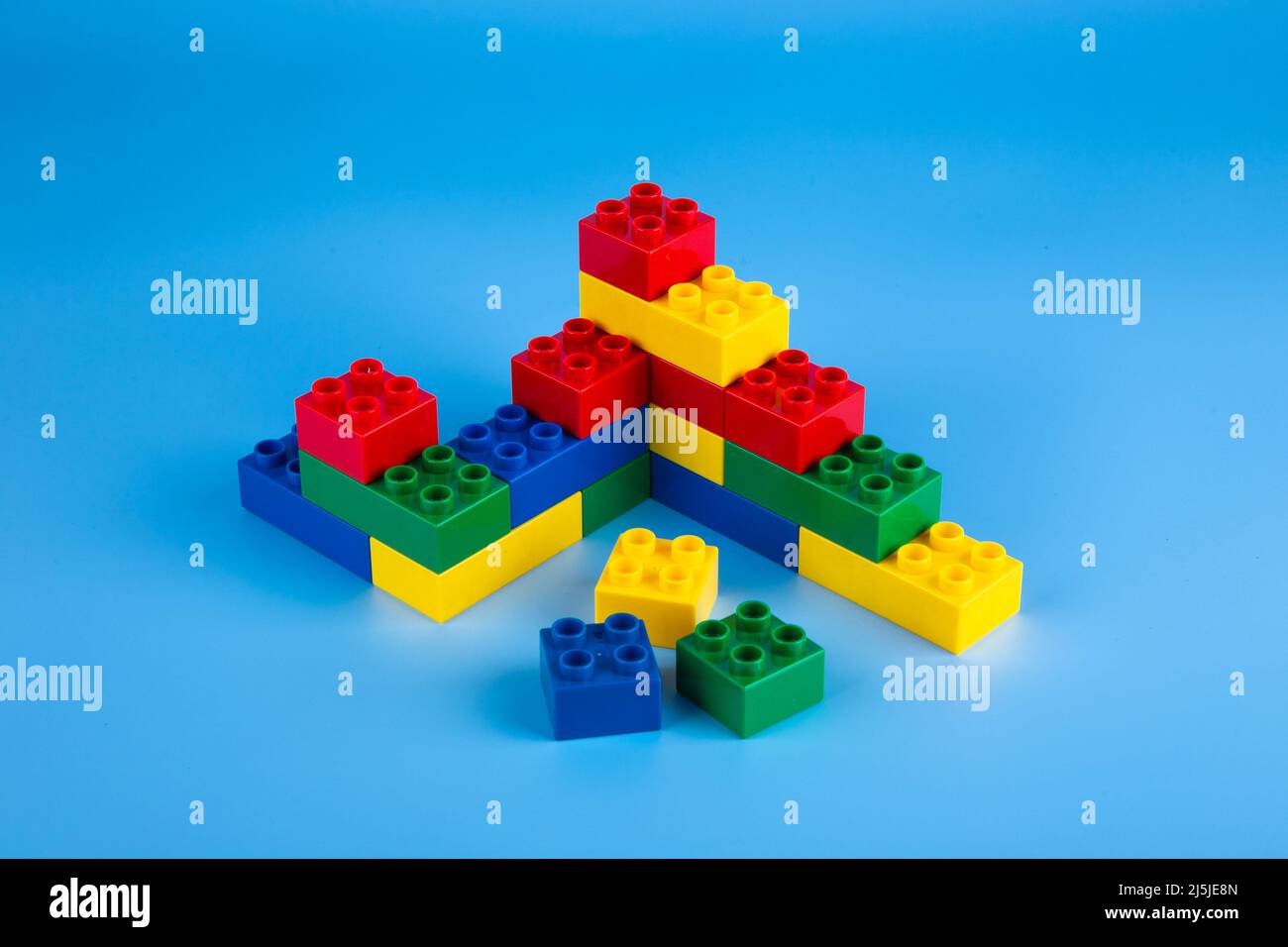 Plastic building blocks on blue background Stock Photo - Alamy