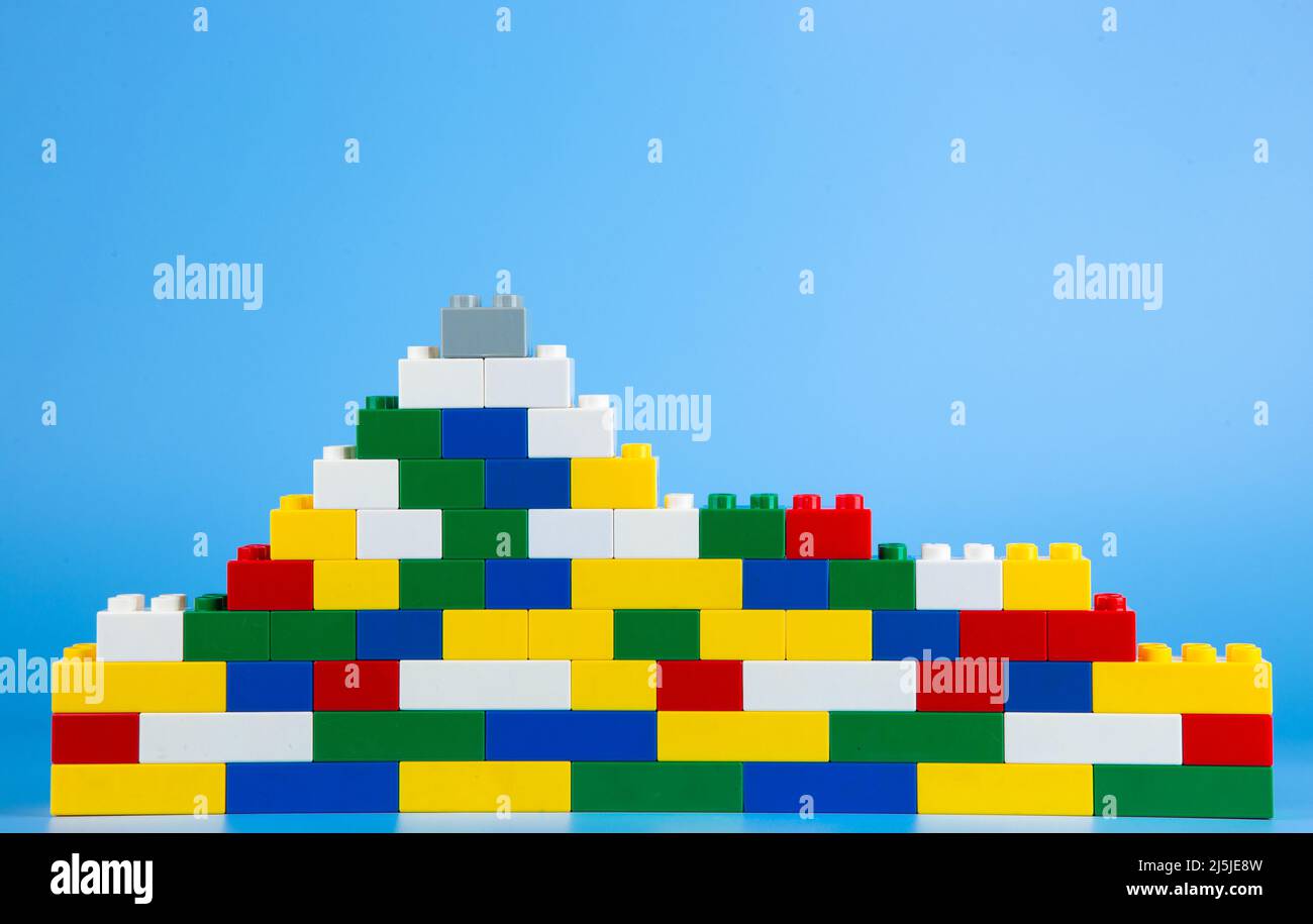 Plastic building blocks on blue background Stock Photo - Alamy