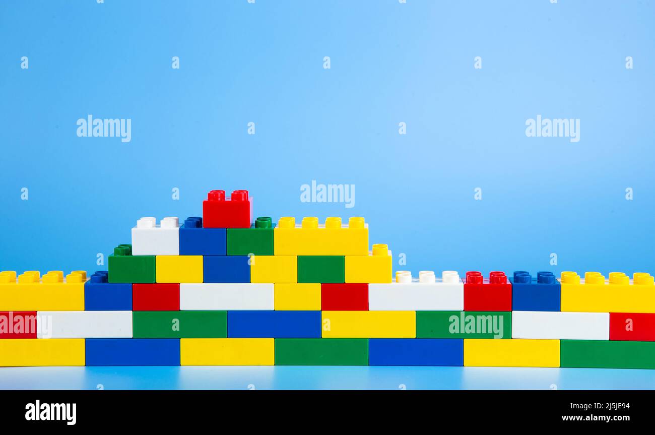Plastic building blocks on blue background Stock Photo - Alamy