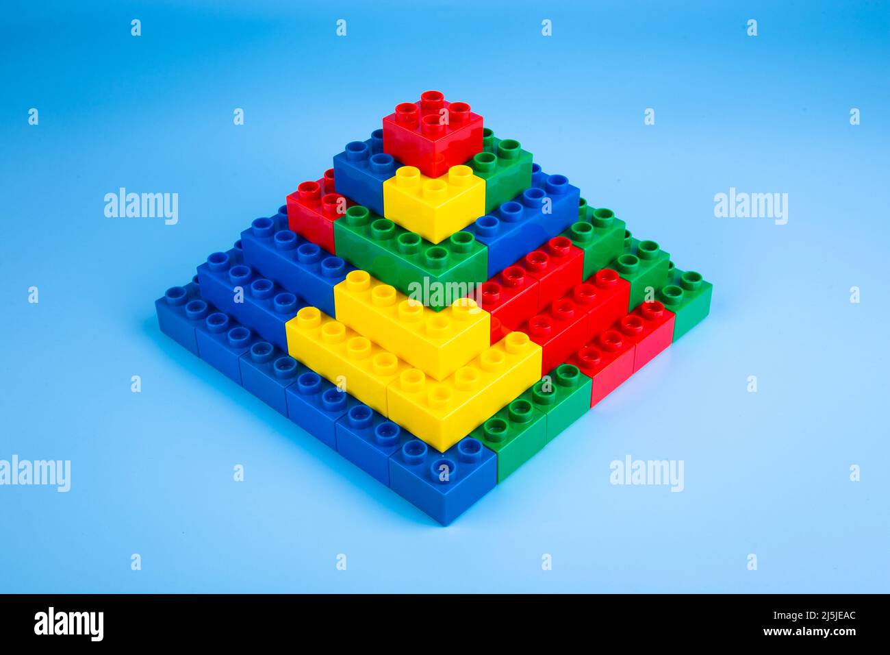 Plastic building blocks on blue background Stock Photo