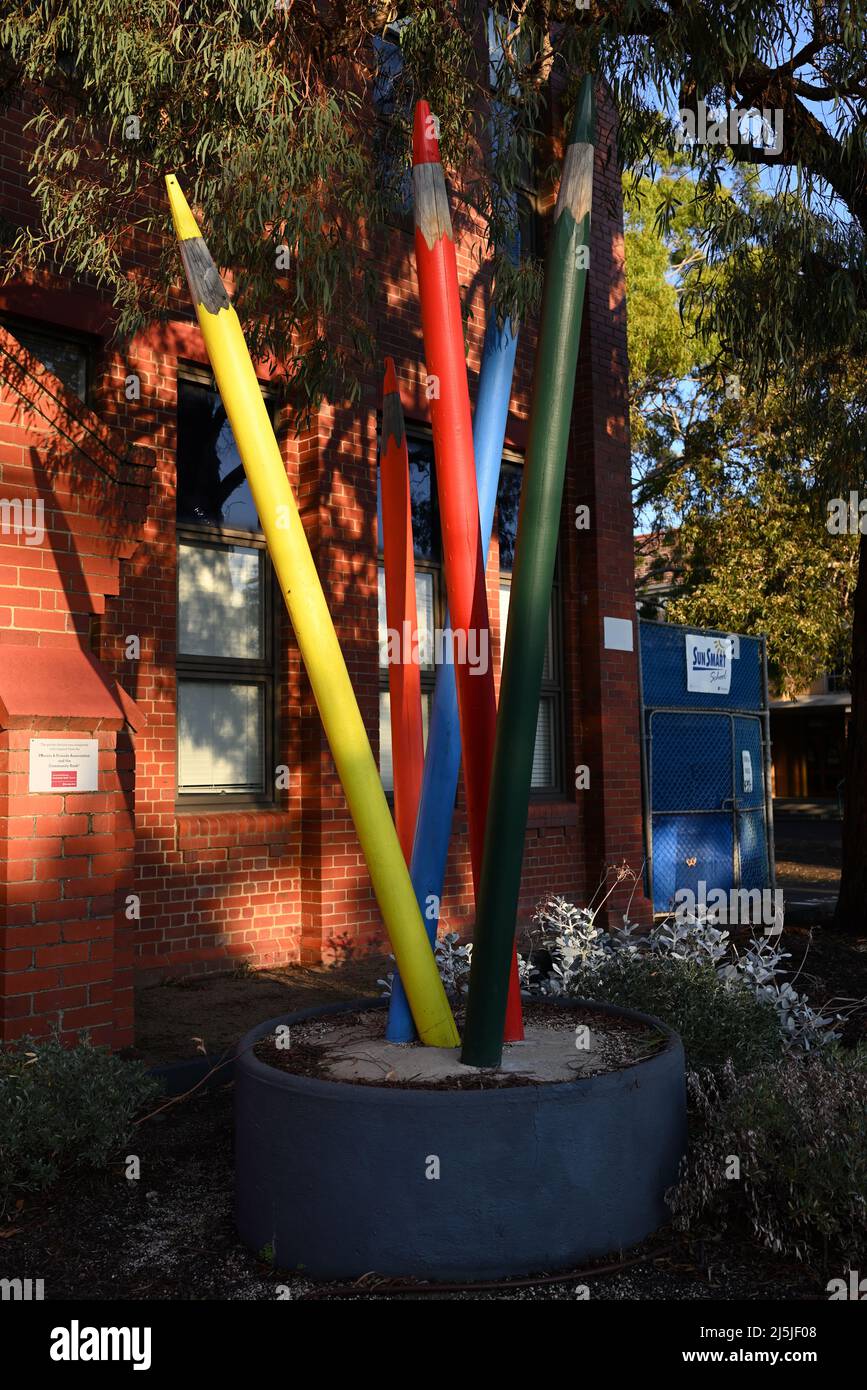 Garden feature in front of St Kevin's Primary School, designed to look like five giant coloured pencils growing out of the ground Stock Photo