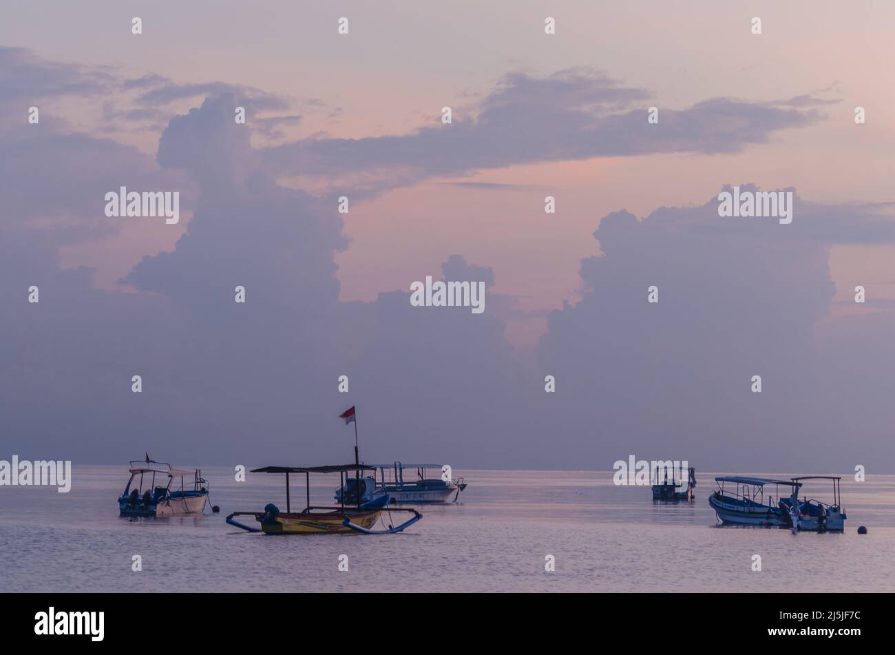 boats in the lilac colored sunrise at the sea Stock Photo