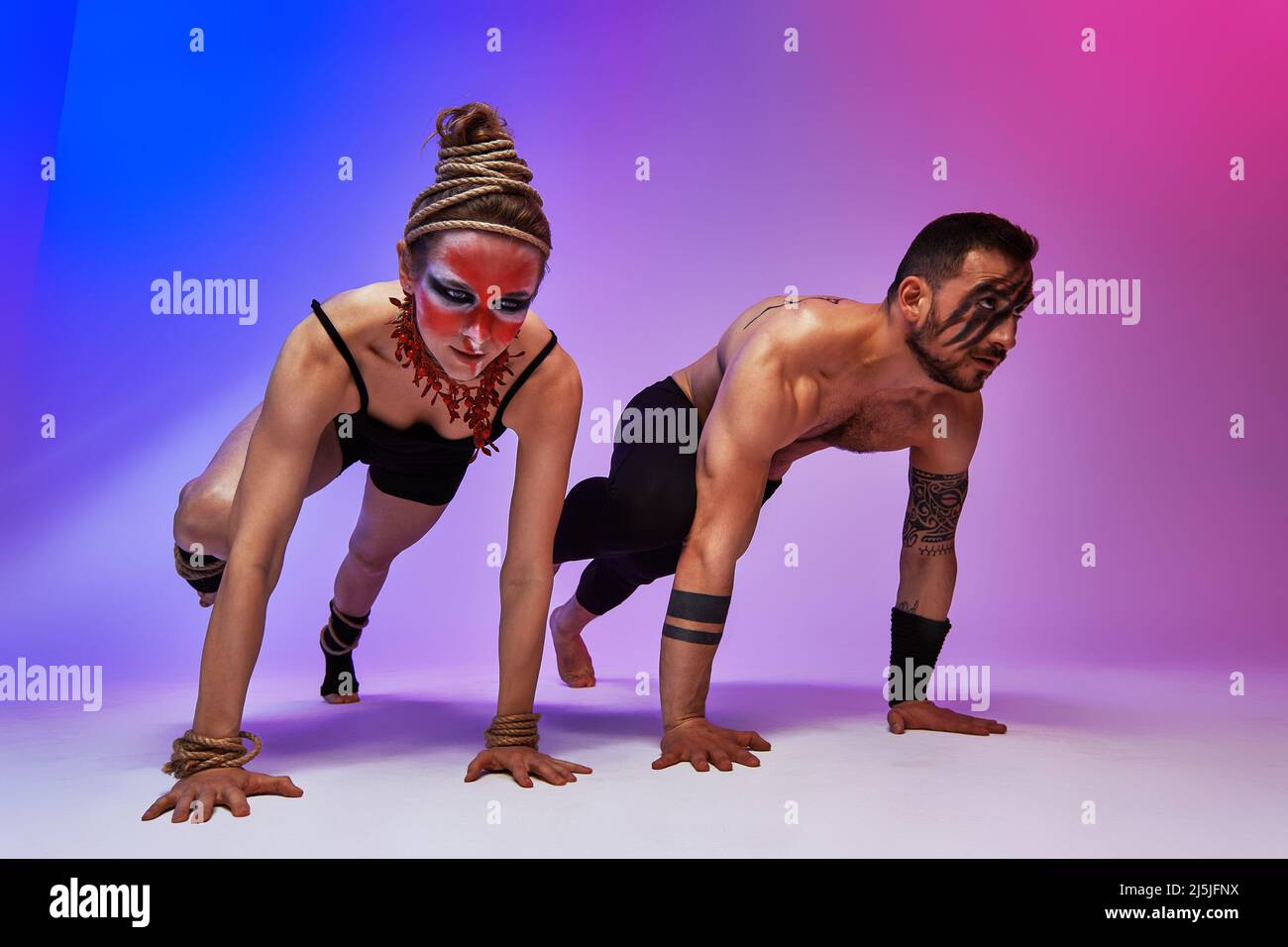 Beautiful young acrobats or gymnasts with colorful face painting on ...
