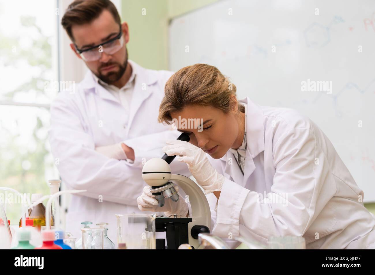 Two scientist colleagues are using microscope during research work in a laboratory Stock Photo
