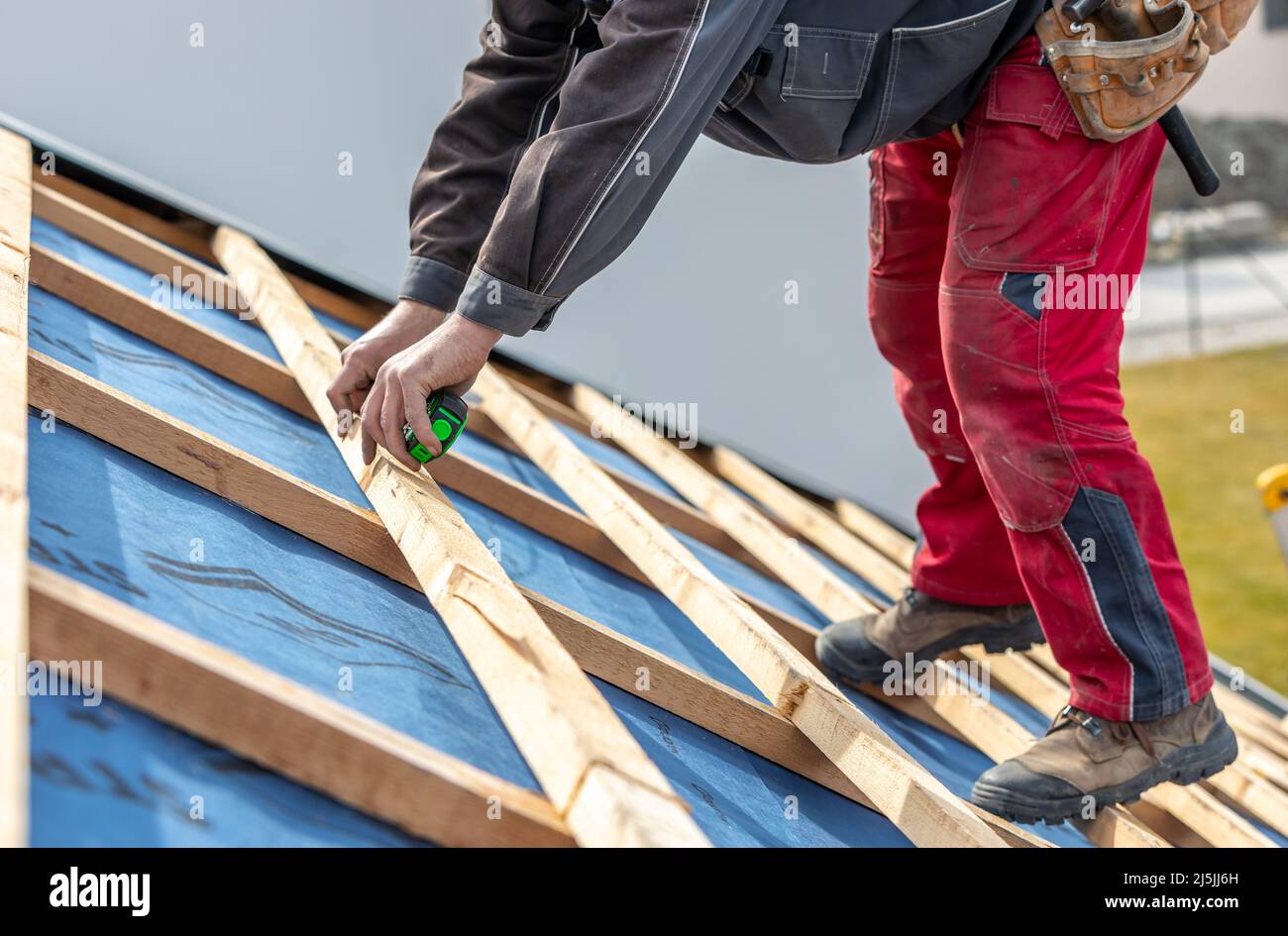 Craftsman or construction worker install a new roof, roofing tools, new metallic roof or metal