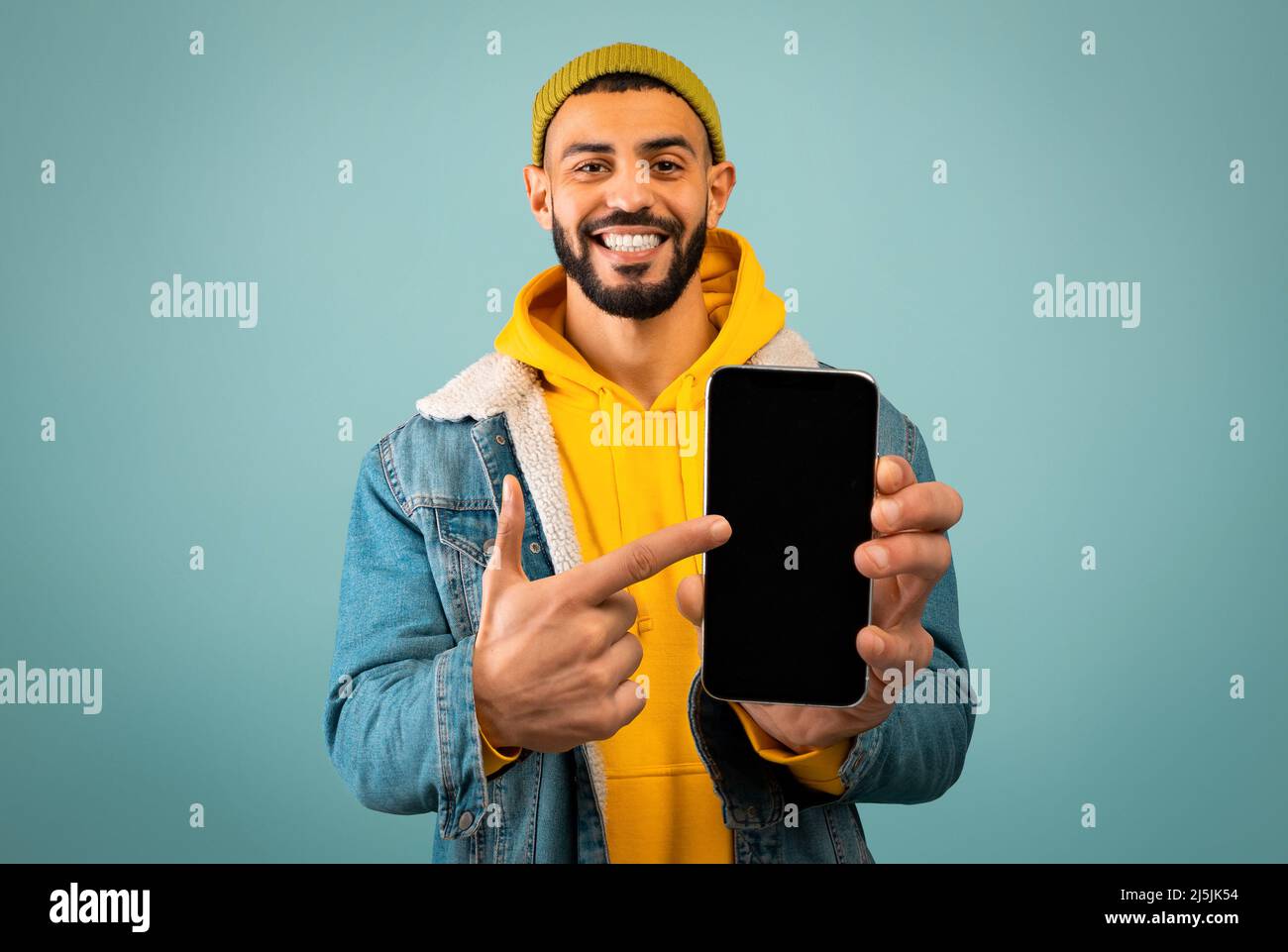 Stylish arab man pointing at smartphone with black screen Stock Photo ...