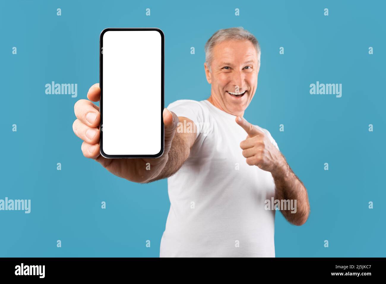 Excited mature man pointing finger at empty smartphone screen Stock Photo