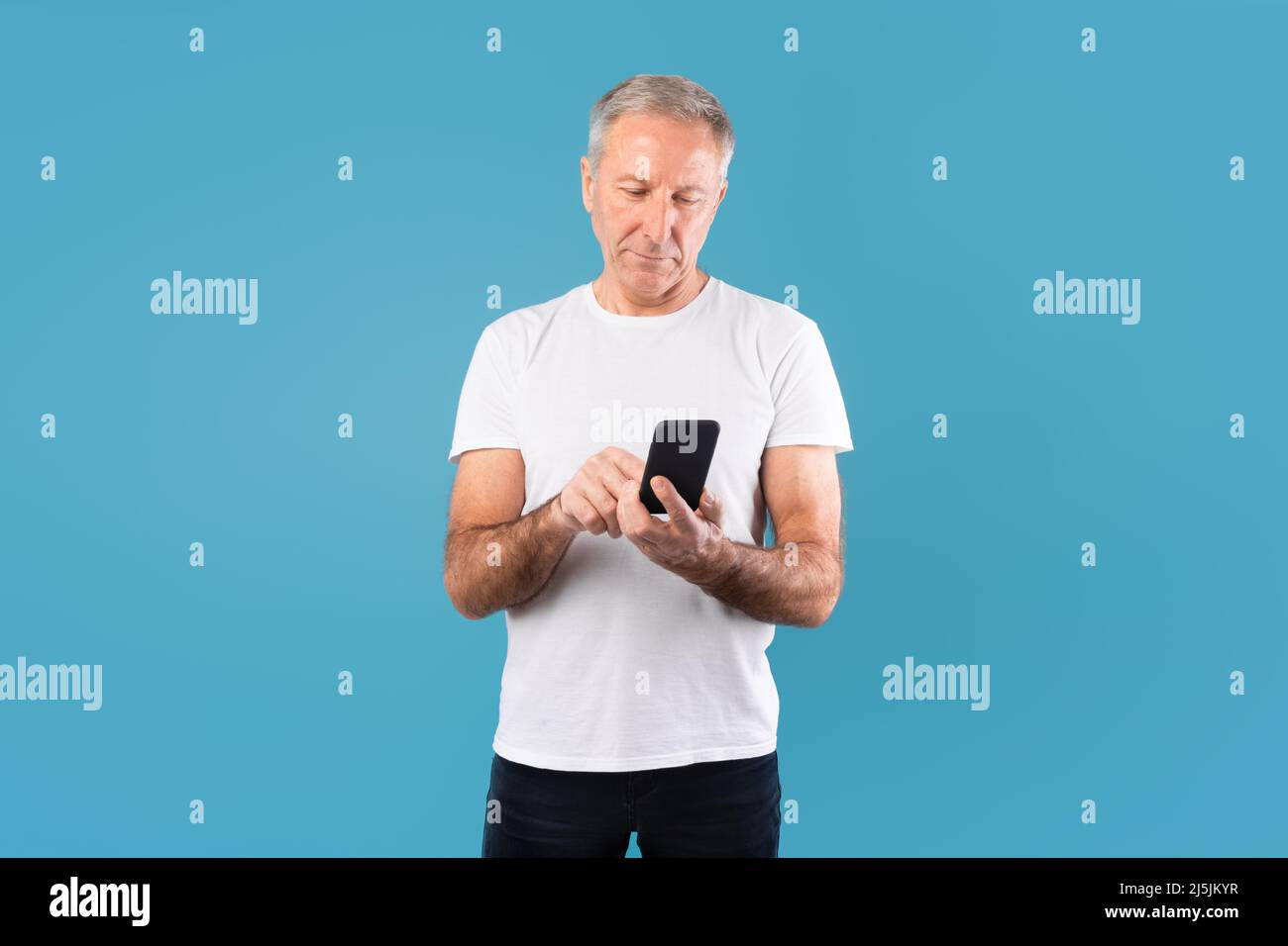 Mature man using his mobile phone at studio Stock Photo