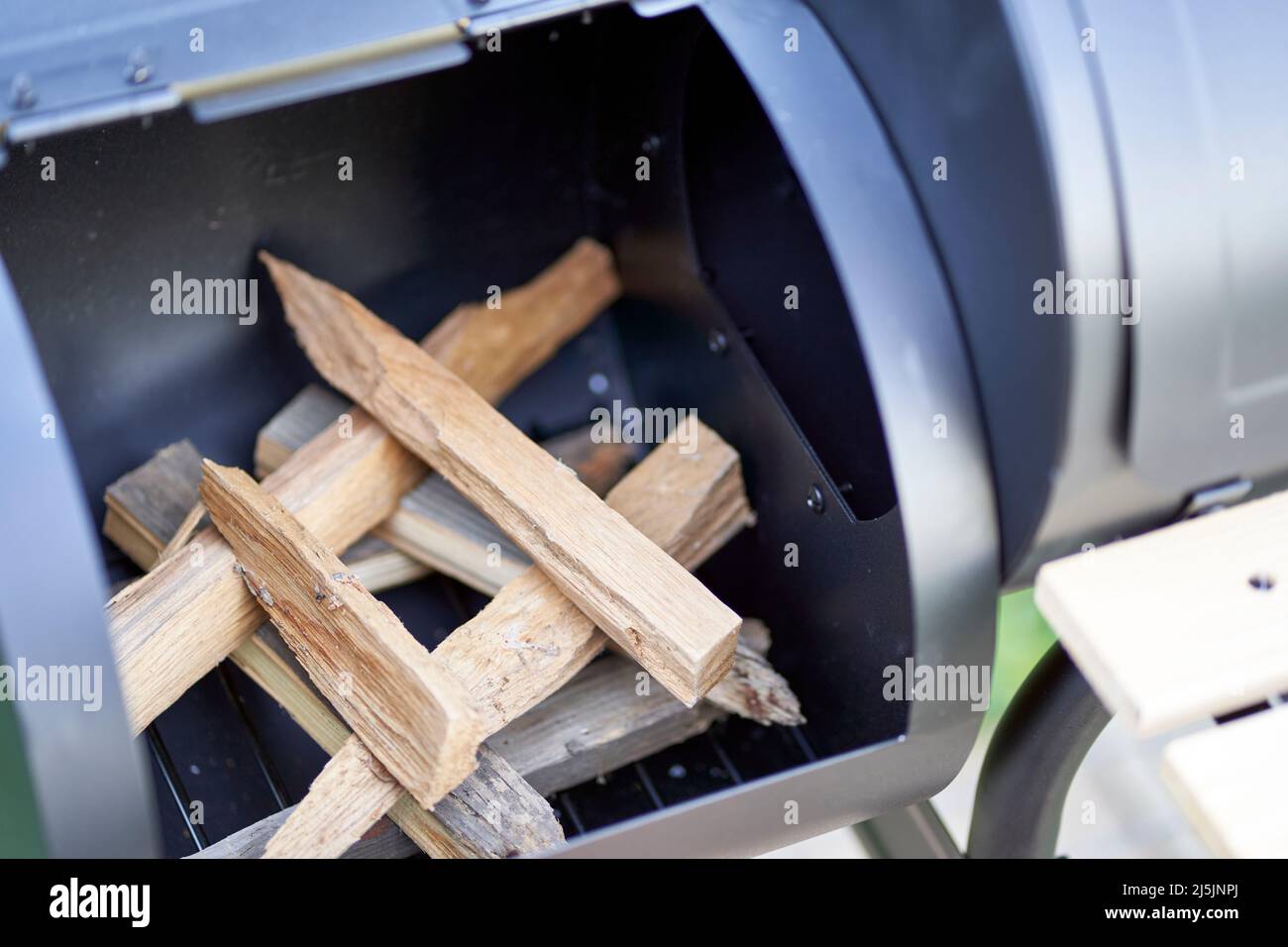 New smoker barbecue grill. Stack wood and light it properly. Closeup ...
