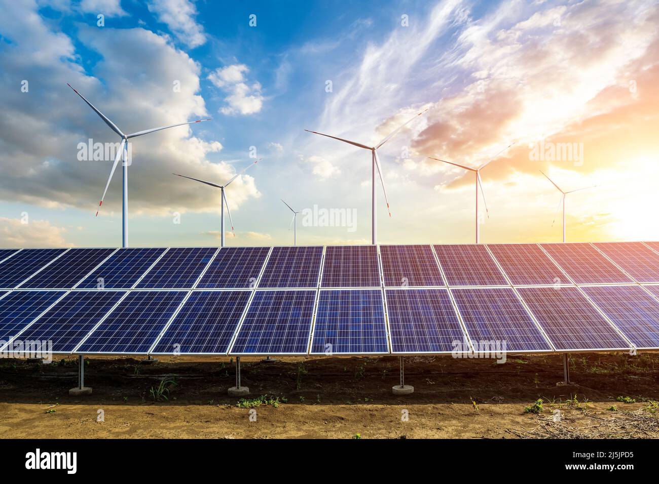 Wind turbines and solar panels at sunset. renewable energy concept ...