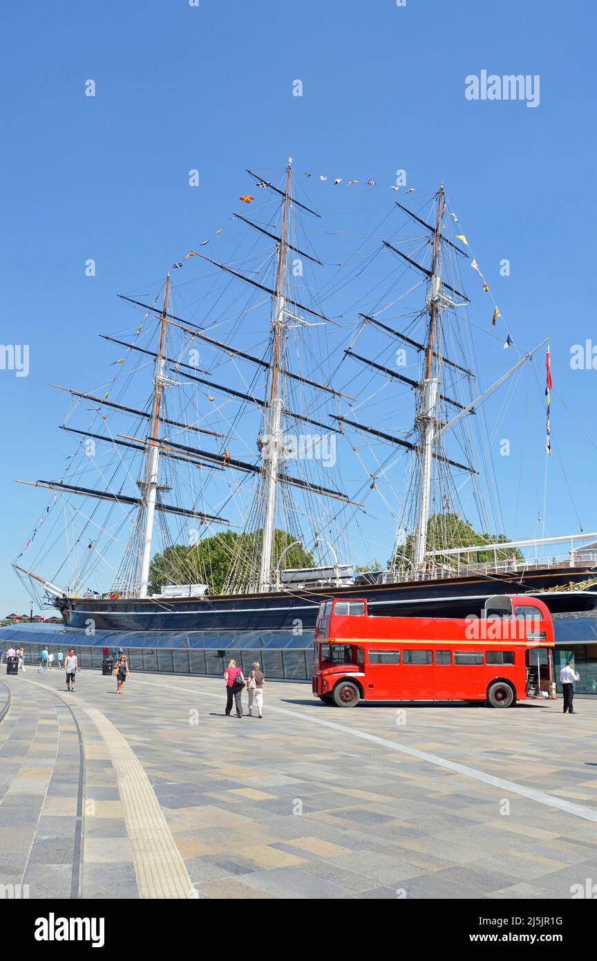 Red London Routemaster open top bus beside historical restored Cutty Sark British tea clipper ship part of National Historic Fleet Greenwich England Stock Photo