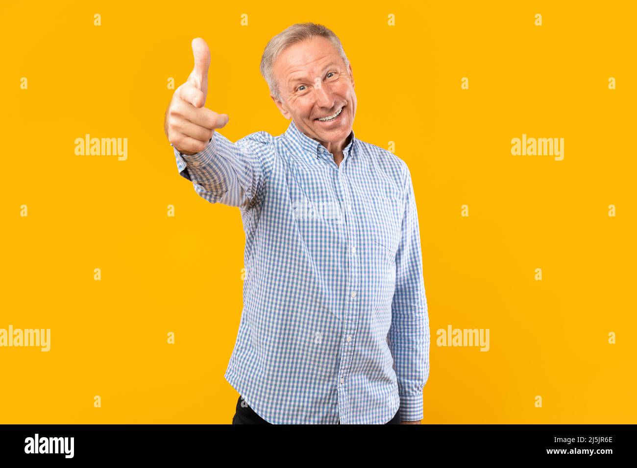 Happy mature man pointing finger at camera at studio Stock Photo