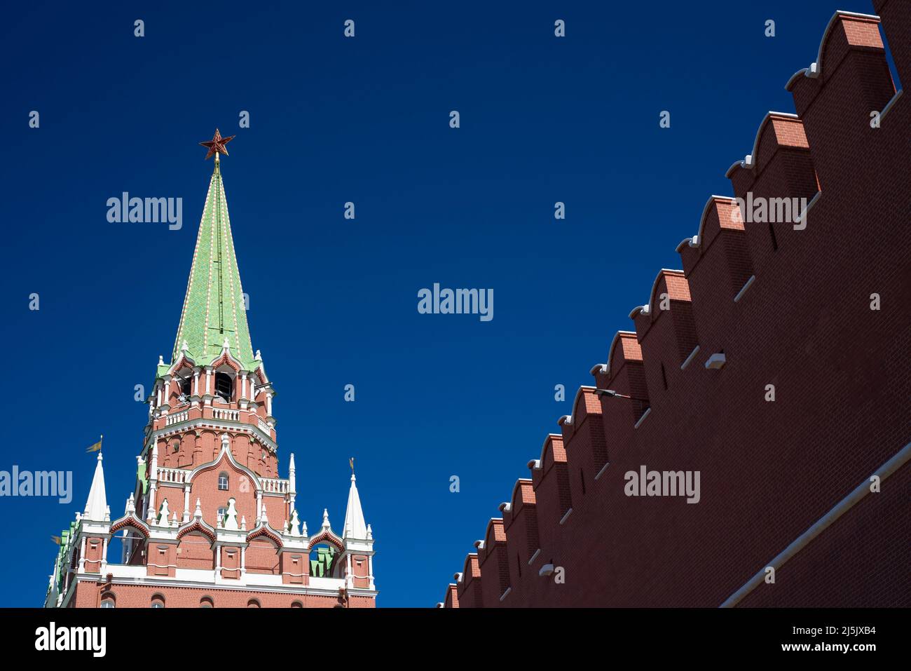 View of the Trinity tower of the Moscow Kremlin with a fortress wall on a Sunny spring day. World tourism, sights of Moscow. High quality photo Stock Photo