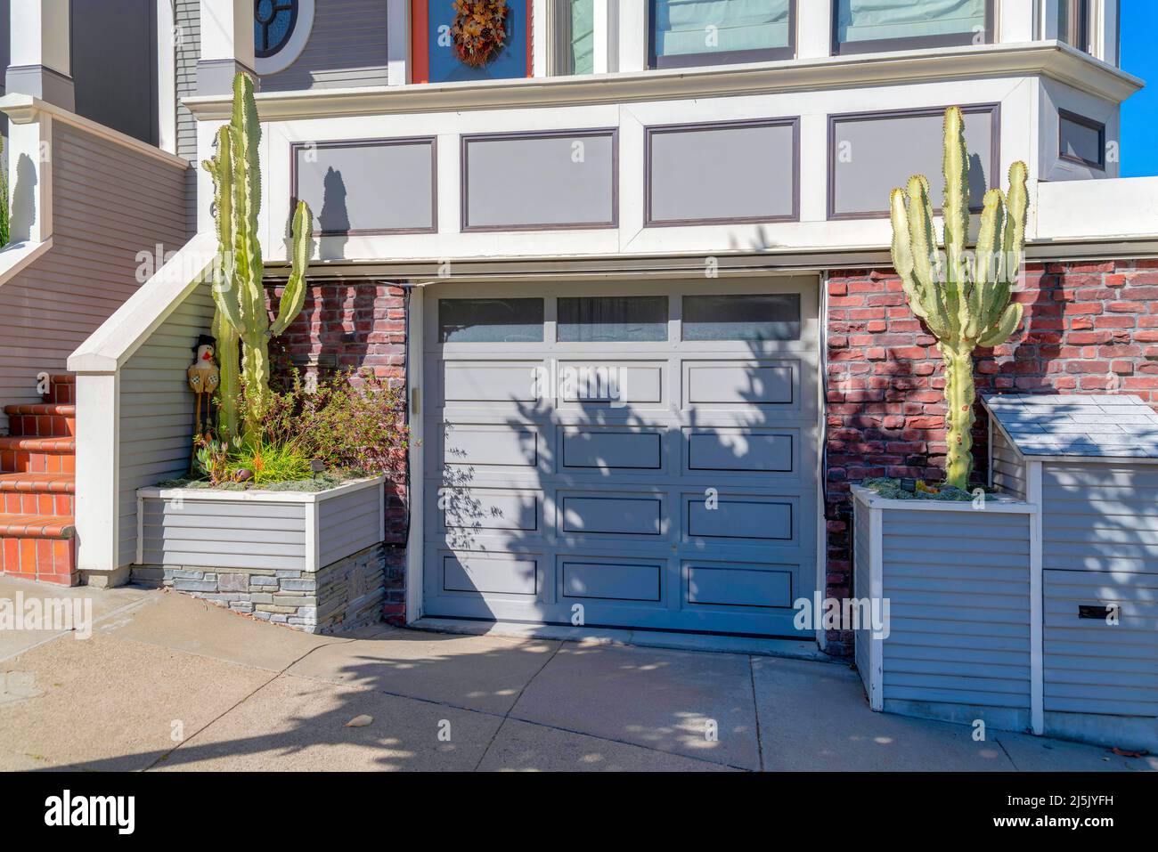 Garage below the porch of townhouse with cactus at the front in San  Francisco, California. There is a paneled garage door beside the stairs  with brick Stock Photo - Alamy