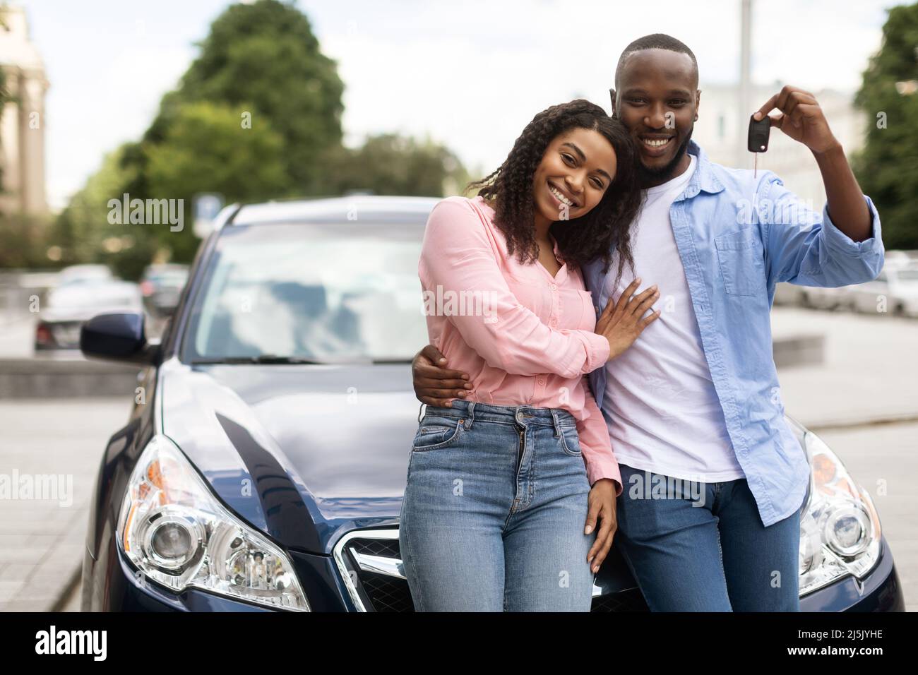 Loving Couple Posing On A Sunset Countryside Road Leaning Against Car Hood  Low Angle View Stock Photo, Picture and Royalty Free Image. Image 145147802.
