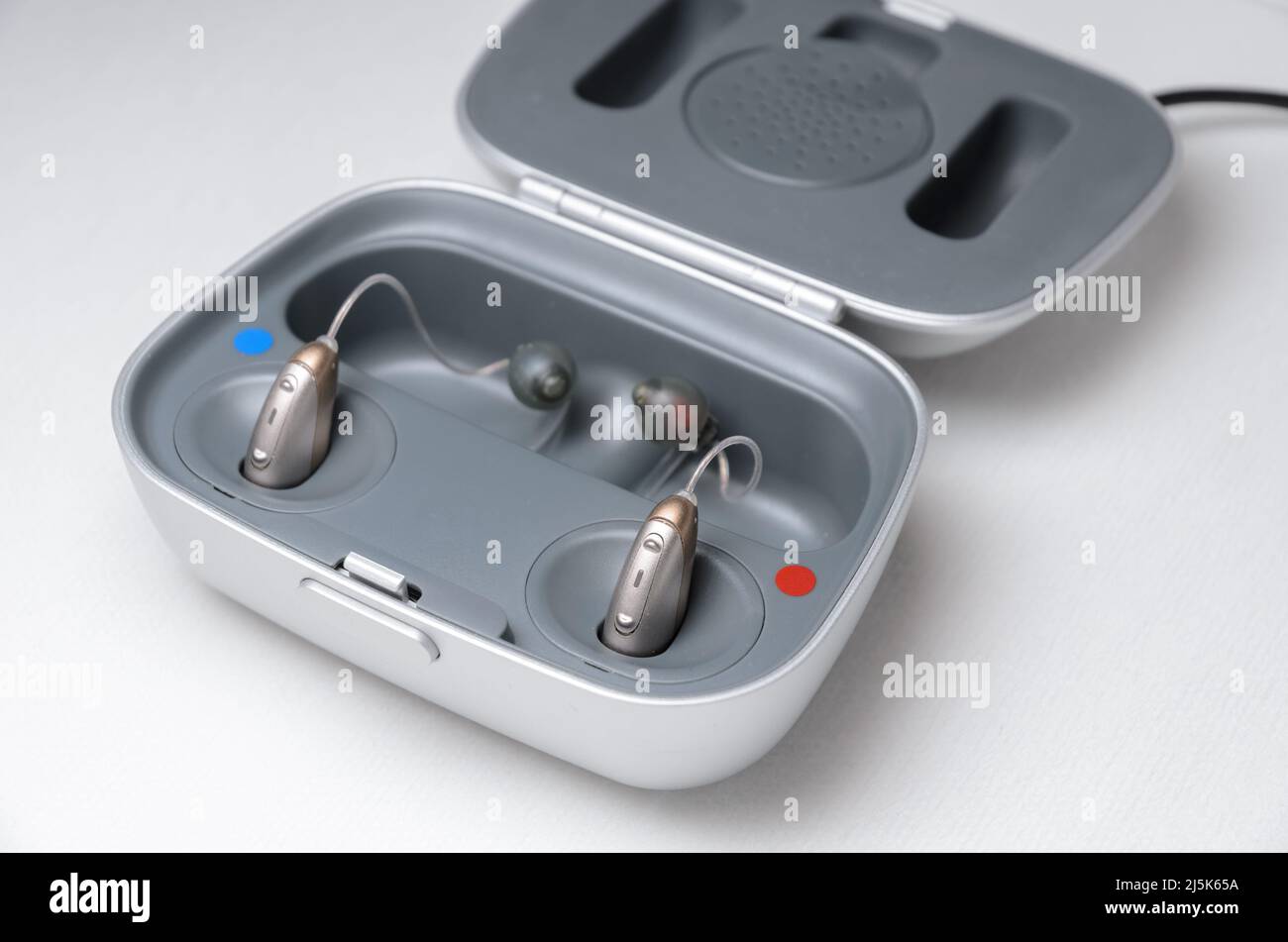 Modern hearing aid with charger on white background Stock Photo Alamy