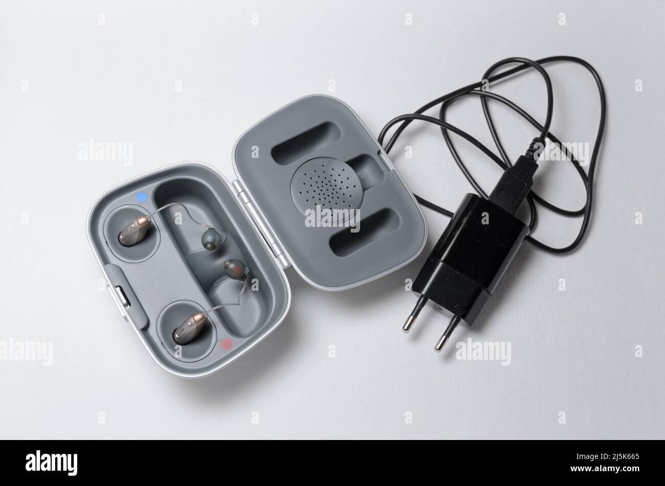 Modern hearing aid with charger on white background Stock Photo Alamy