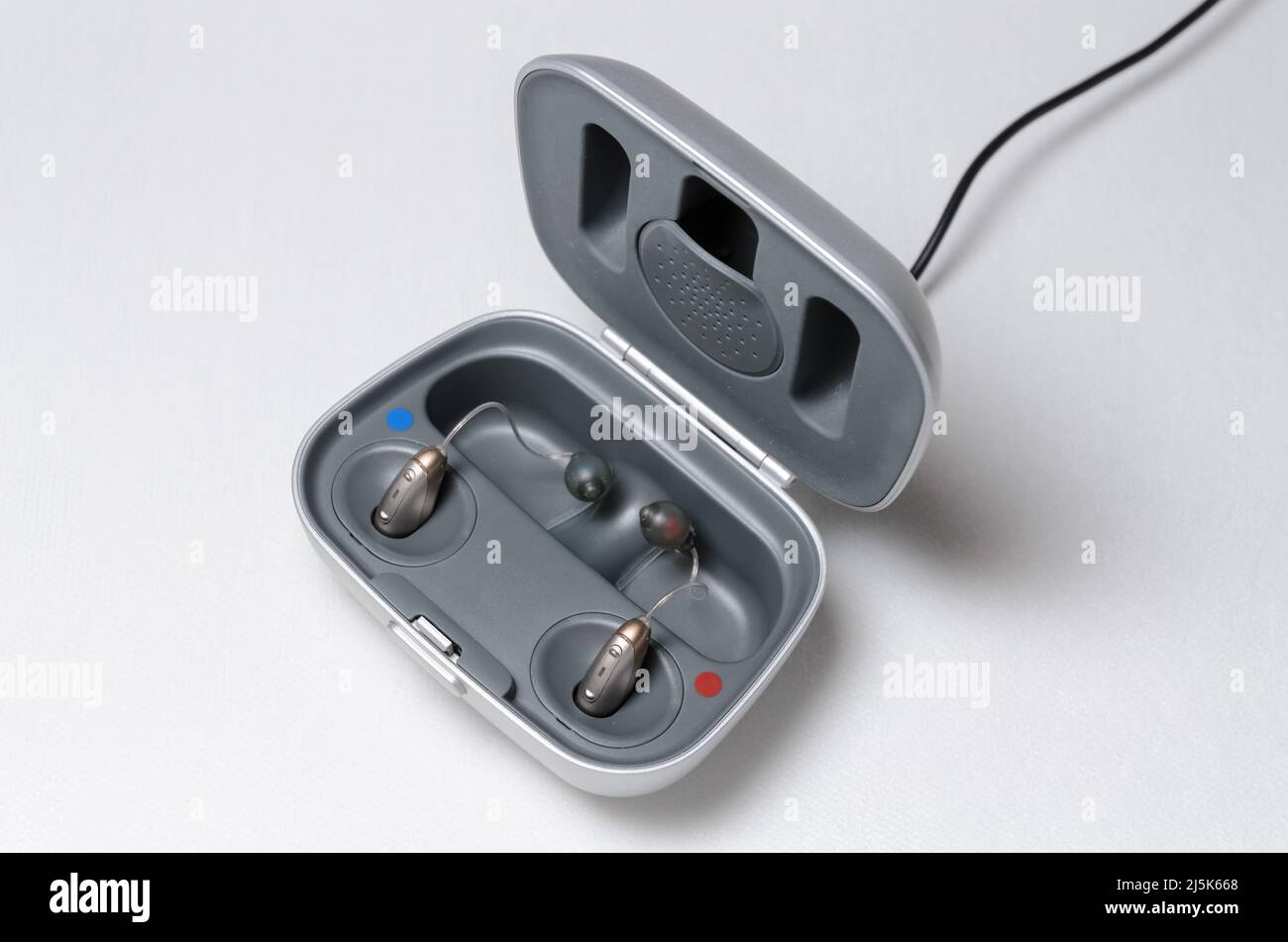 Modern hearing aid with charger on white background Stock Photo Alamy