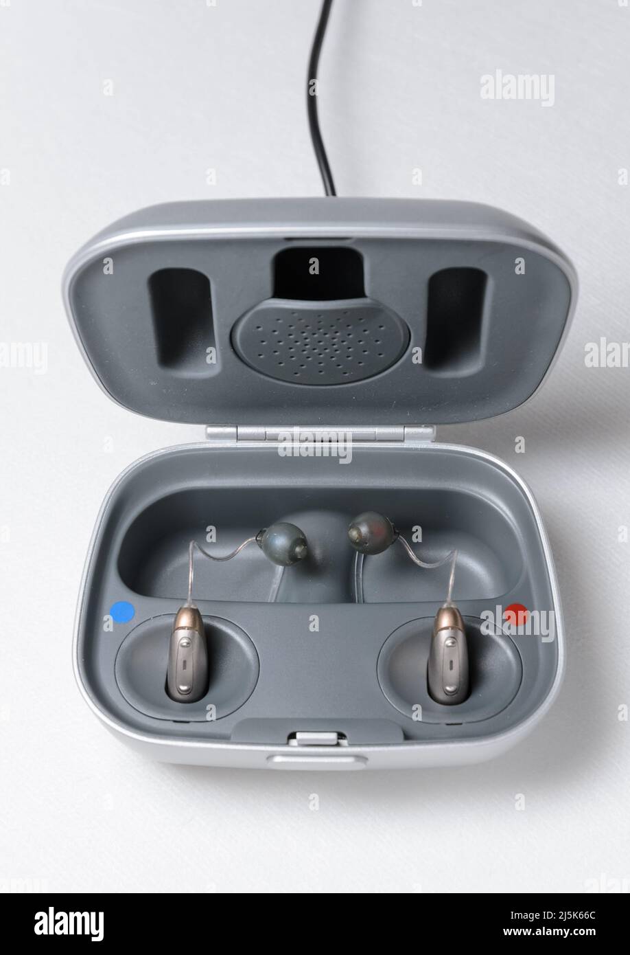 Modern hearing aid with charger on white background Stock Photo Alamy