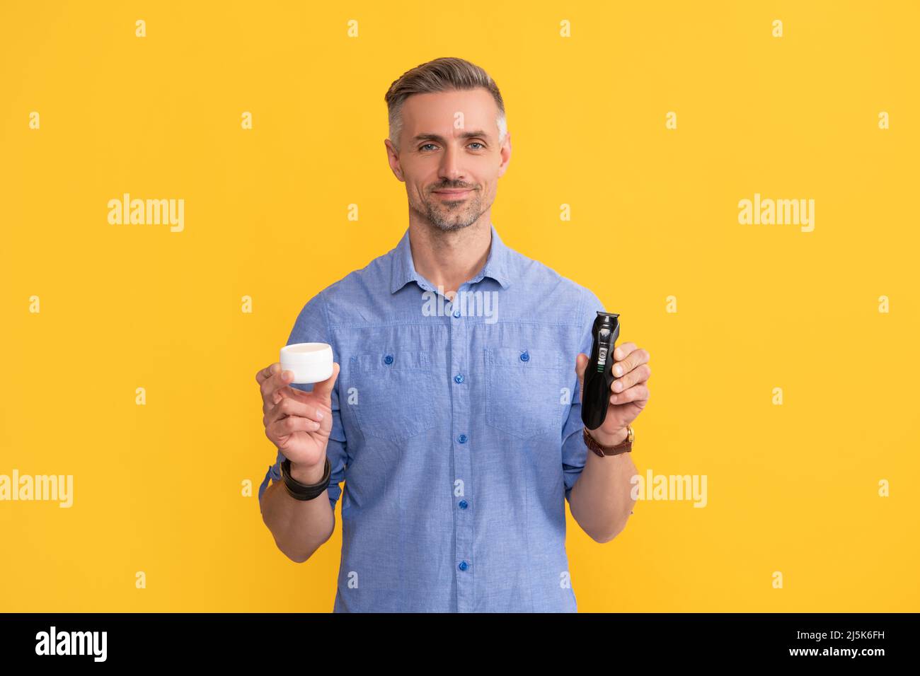 mens beauty. after shave. man holding electric shaver and cream Stock Photo Alamy