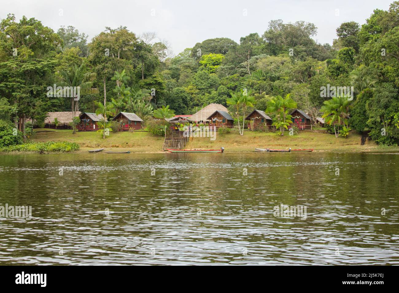 Eco-friendly Danpaati Lodge on the banks of Suriname River with a canoe moored, Upper Suriname, South America Stock Photo