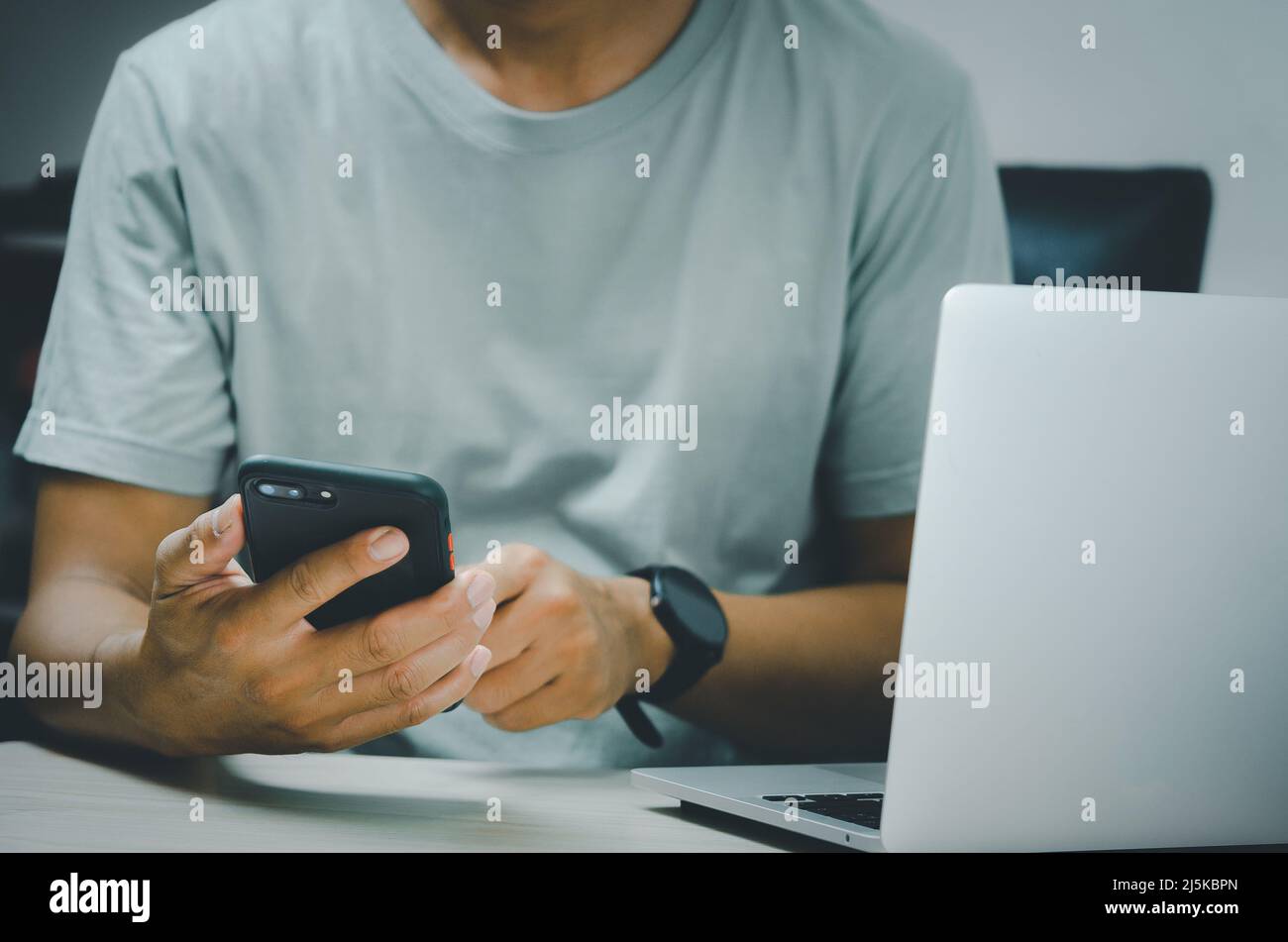 man hand holding smartphone and computer laptop to working technology ...