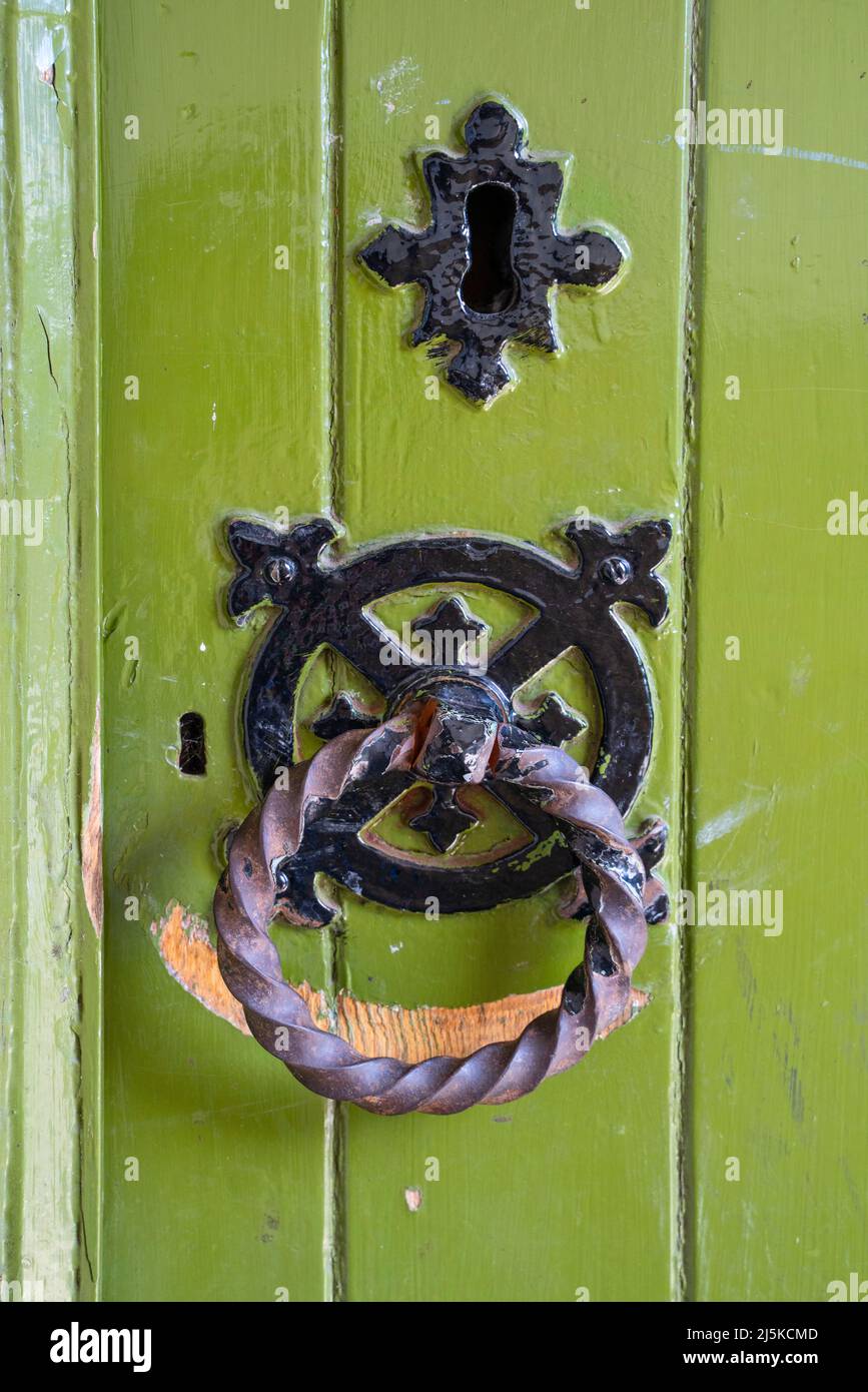 Green painted wooden church door with rusted ring handle Stock Photo