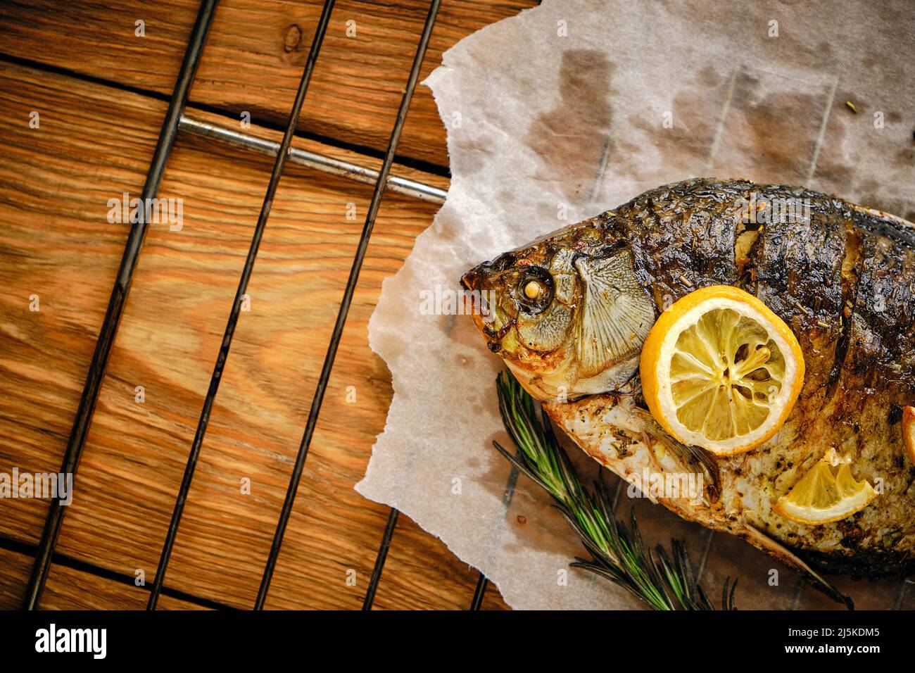 Baked fish cooked on parchment paper with spices, lemon and rosemary