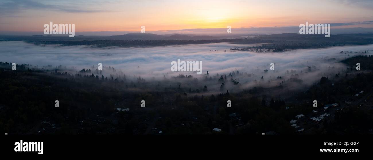 A colorful sunrise illuminates a layer of fog that covers the scenic Willamette River not far south of Portland, Oregon. Stock Photo