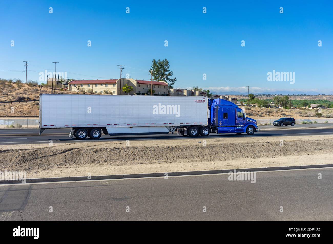 Apple Valley, CA, USA – April 20, 2022: A semi-truck traveling on State Highway 18 in Apple Valley, California. Stock Photo