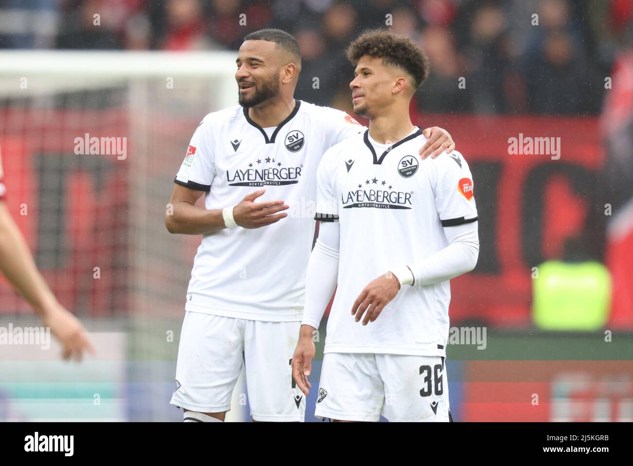 Nuremberg, Germany. 24th Apr, 2022. Soccer: 2nd Bundesliga, 1. FC Nürnberg - SV Sandhausen, Matchday 31 at Max Morlock Stadium. Erik Zenga (l) and Chima Okoroji of SV Sandhausen celebrate their victory after the final whistle. Credit: Daniel Karmann/dpa - IMPORTANT NOTE: In accordance with the requirements of the DFL Deutsche Fußball Liga and the DFB Deutscher Fußball-Bund, it is prohibited to use or have used photographs taken in the stadium and/or of the match in the form of sequence pictures and/or video-like photo series./dpa/Alamy Live News Stock Photo