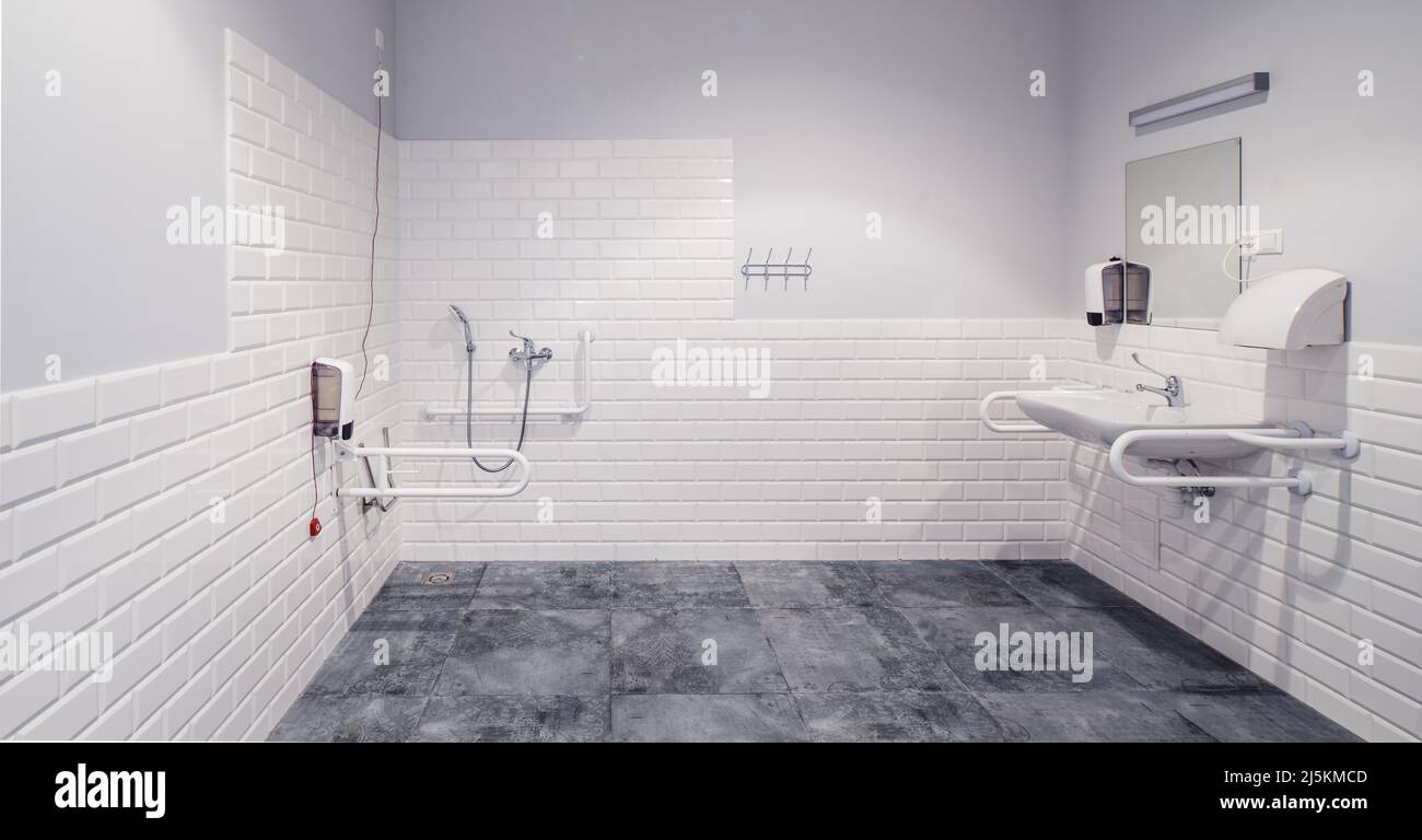 The interior of bathroom with facilities for the disabled. White bricks