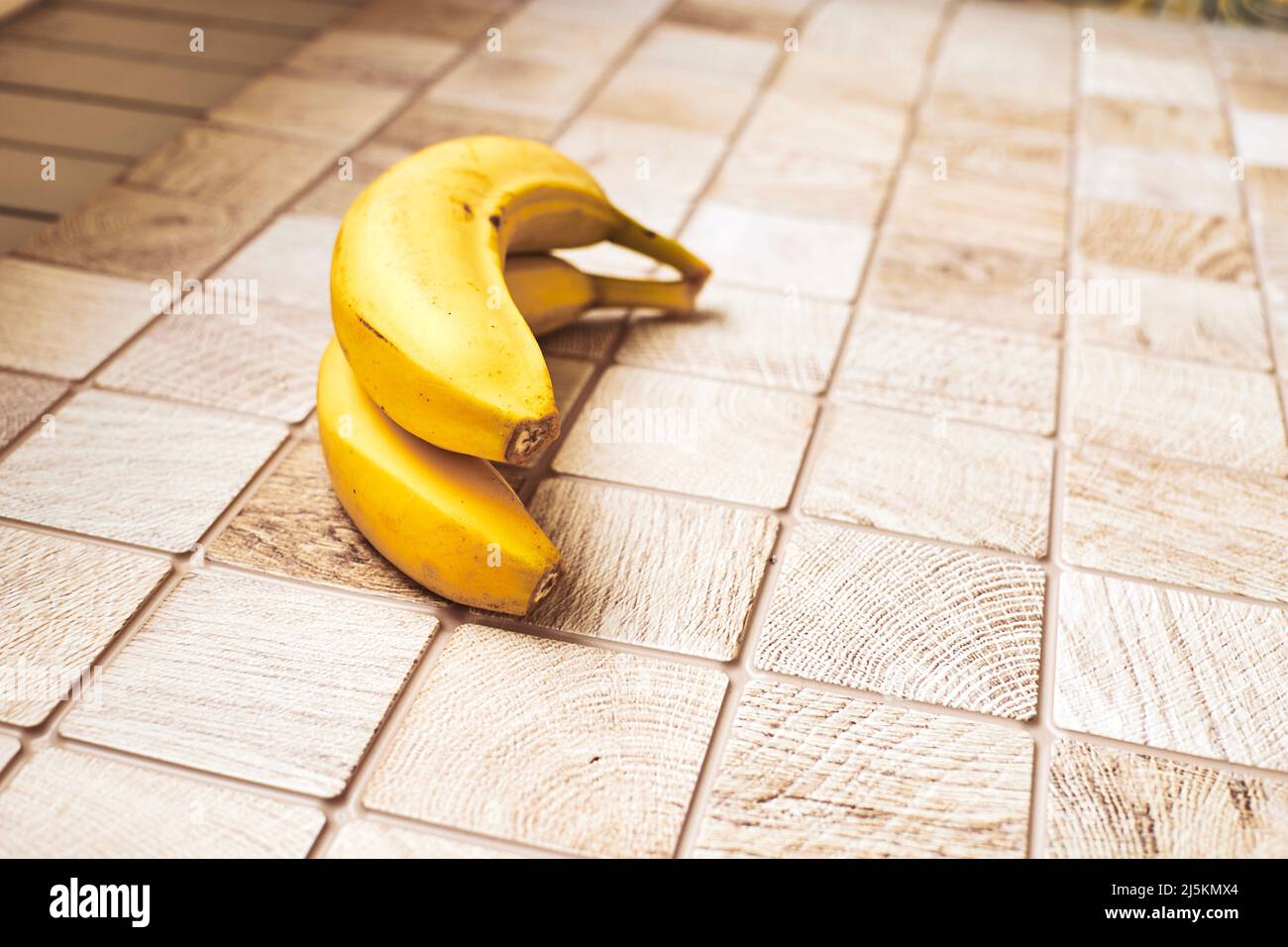 Two ripe bananas on a checkered wooden surface Stock Photo