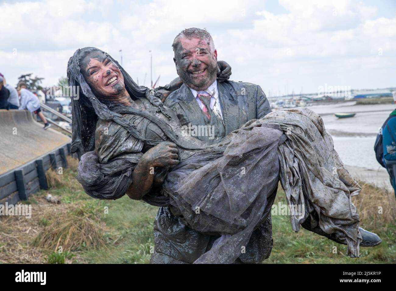 Maldon, Essex, UK. 24th April 2022. Newlywed competitors take part in the Maldon Mud Race in Maldon, Essex on April 24th 2022 as the race returns for the first time in two years. Credit: Lucy North/Alamy Live News Stock Photo