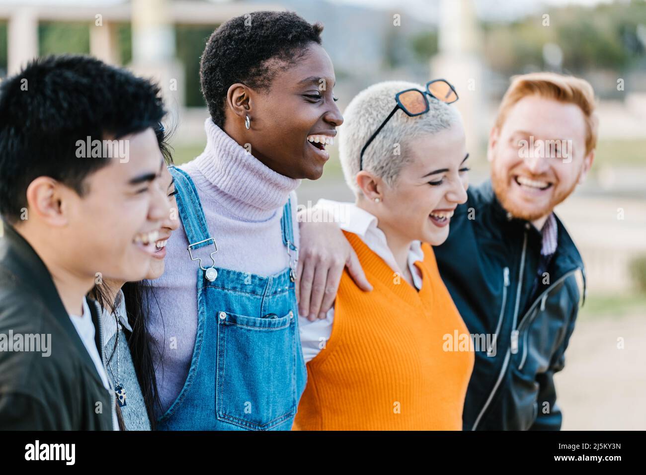 Group of happy best multiracial friends hugging together each other outdoor Stock Photo