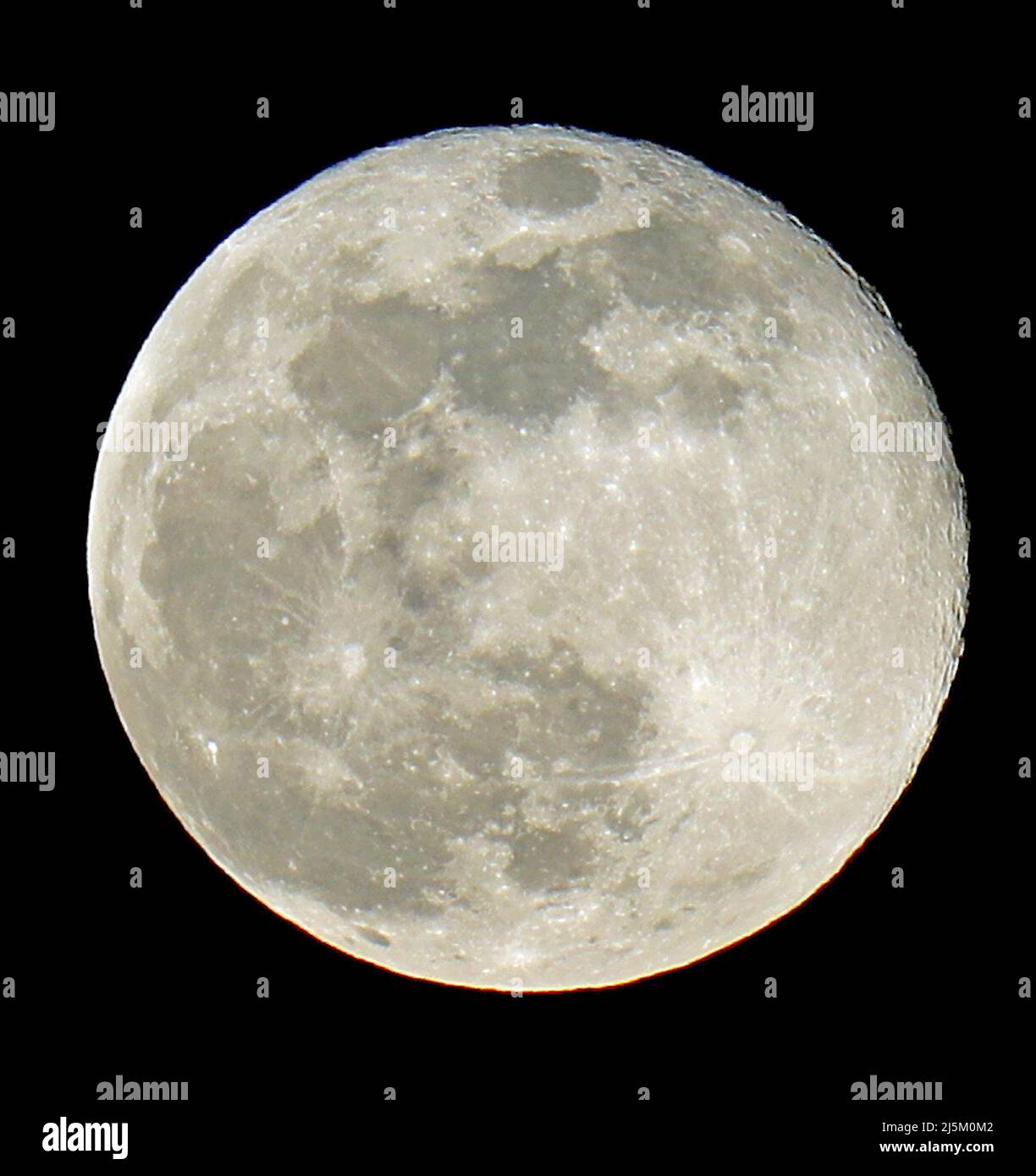 Immense moon during the full moon phase and the lunar craters clearly visible in the black sky Stock Photo