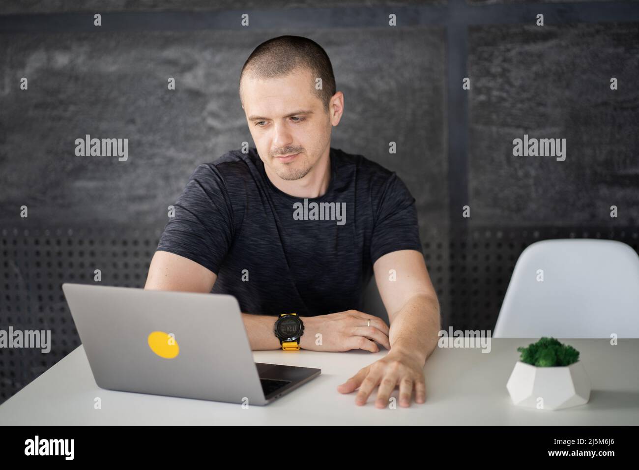 Happy man working on laptop in library or coworking office space Stock Photo