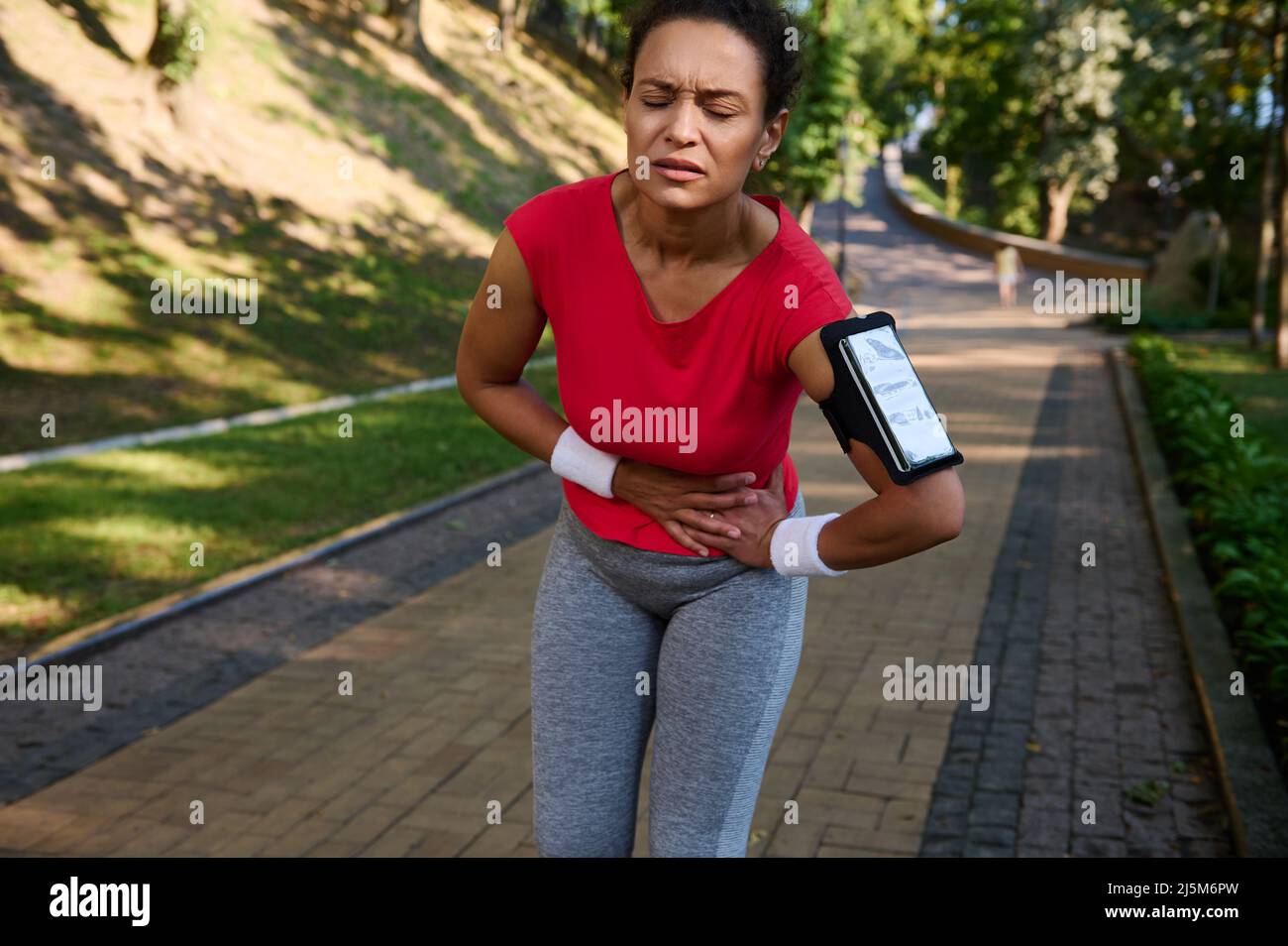 Female runner, African American sportswoman feeling exhaustion and side