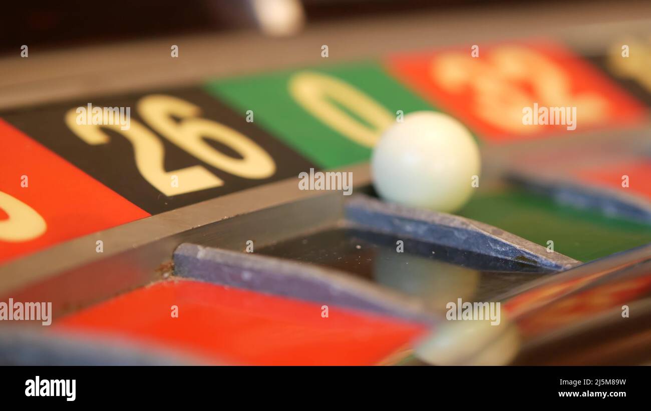Ball on wooden french roulette table in casino. Wheel spinning, turning or rotating. Odd and even numbers, black, red and zero sectors. Bets in game of chance. Money playing, gambling or risky betting Stock Photo
