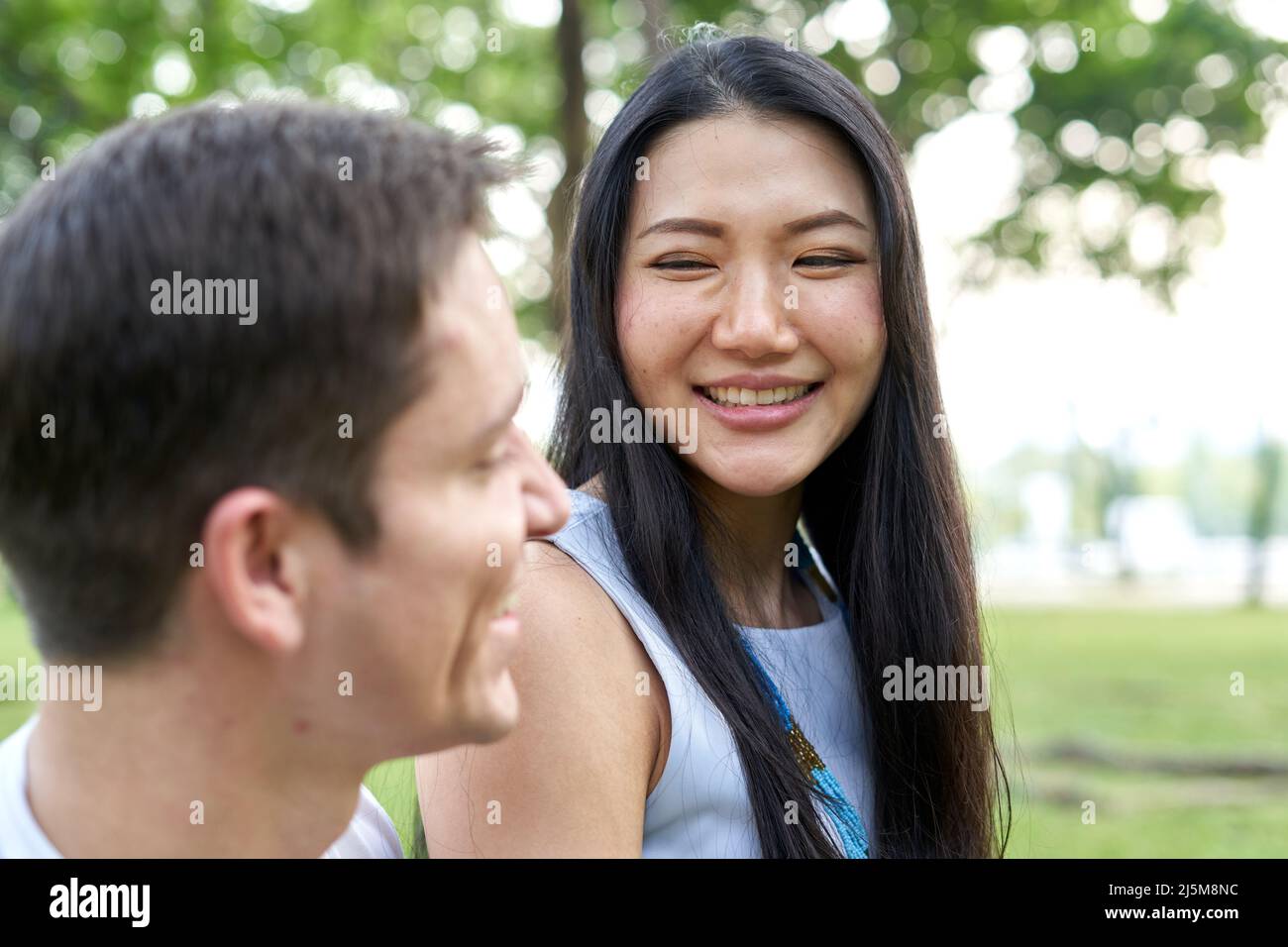 Smiling thai woman looking to his couple in a park Stock Photo