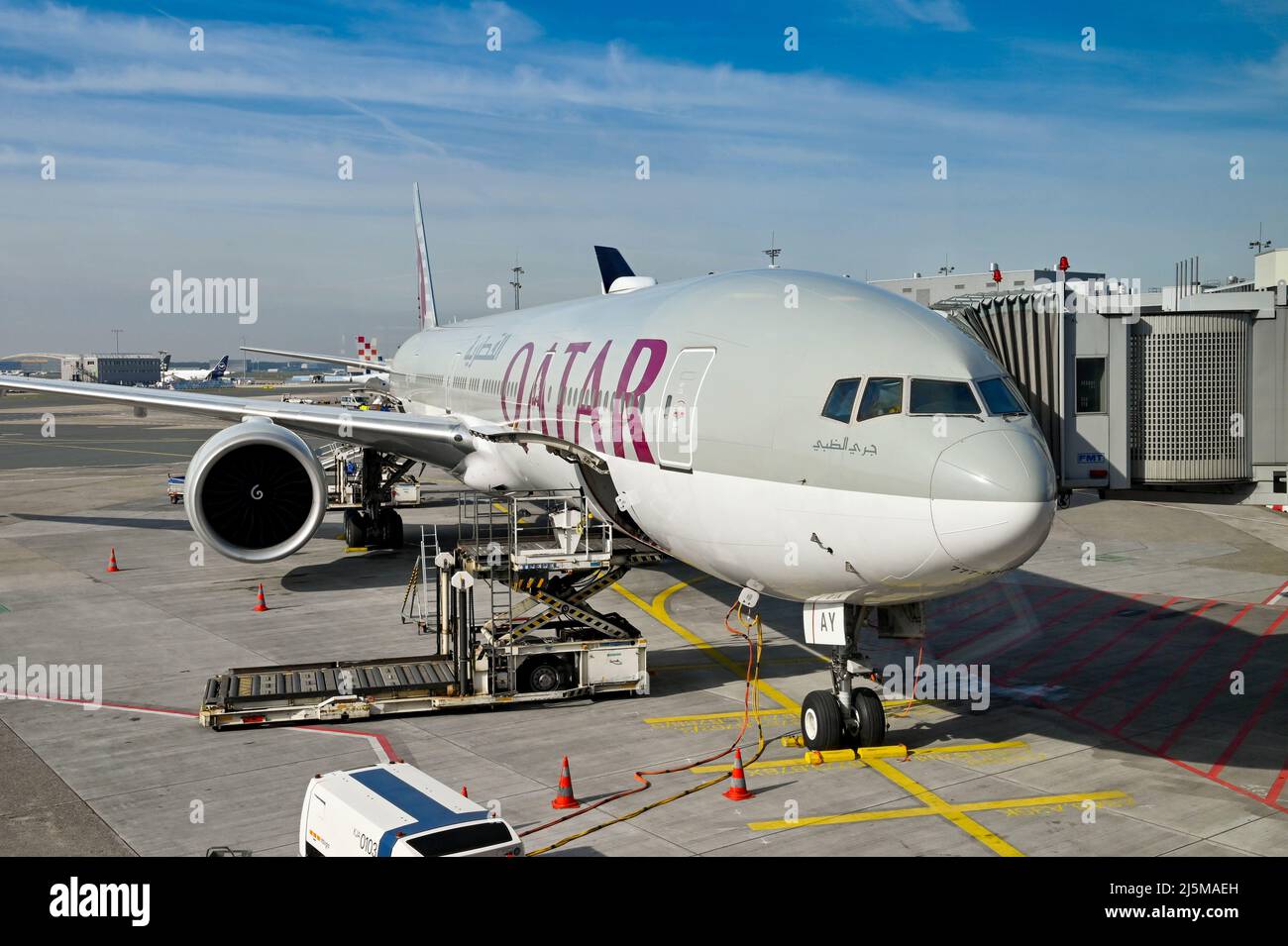 Frankfurt, Germany - April 2022: Air freight pallet loader alongside the open cargo hold of a Qatar Airways Boeing 777 jet. Stock Photo