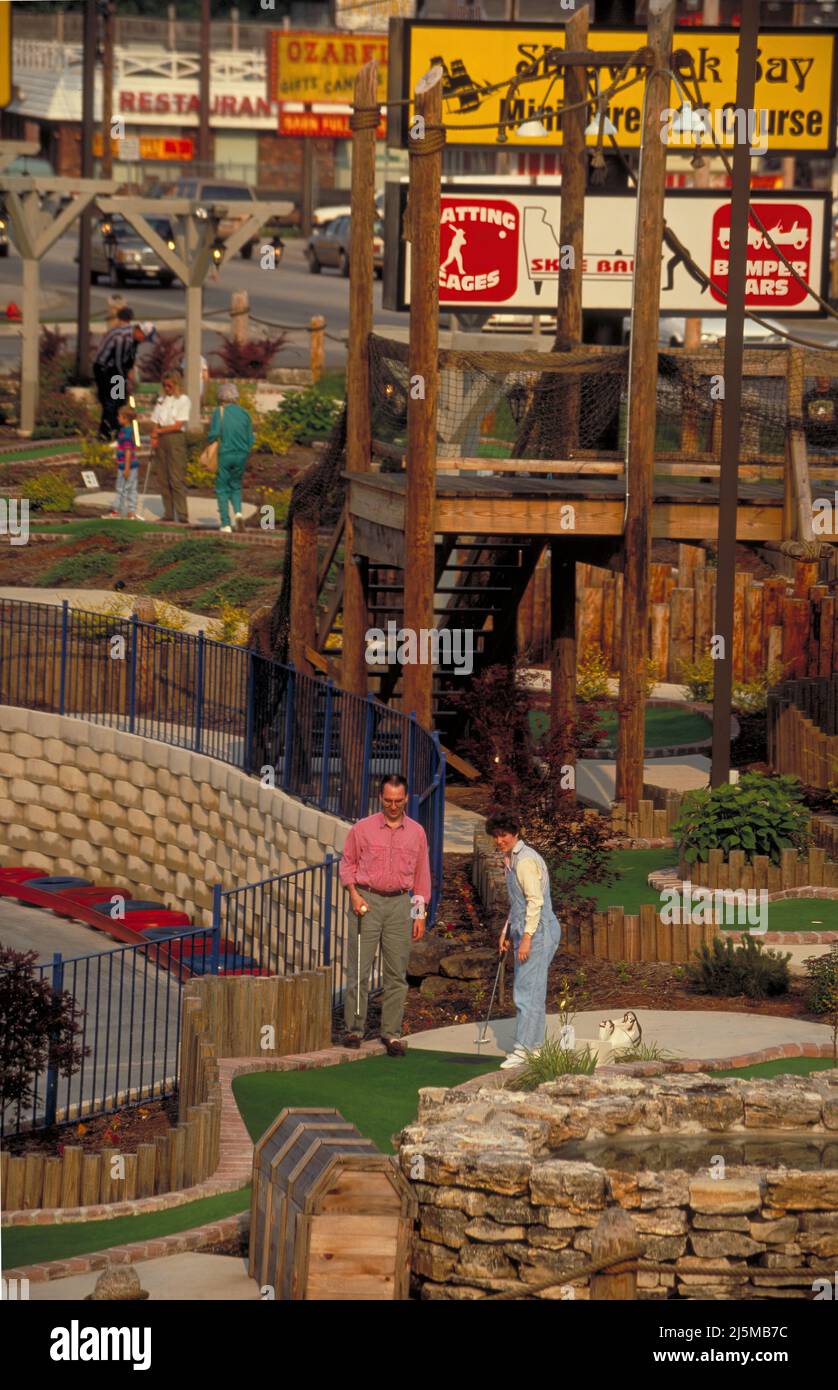 Branson, Missouri USA May 16, 1994: A couple plays a round of miniature golf at one of the many entertainment venues along Highway 76 in Branson, Missouri. Stock Photo
