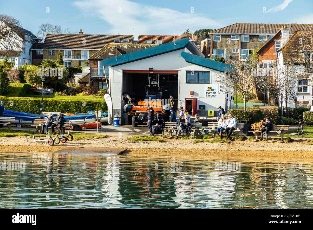 Landscape of Hamble lifeboat station on a sunny spring afternoon, people enjoying the view of the River Hamble, Hamble-le-Rice  Hampshire, England UK Stock Photo