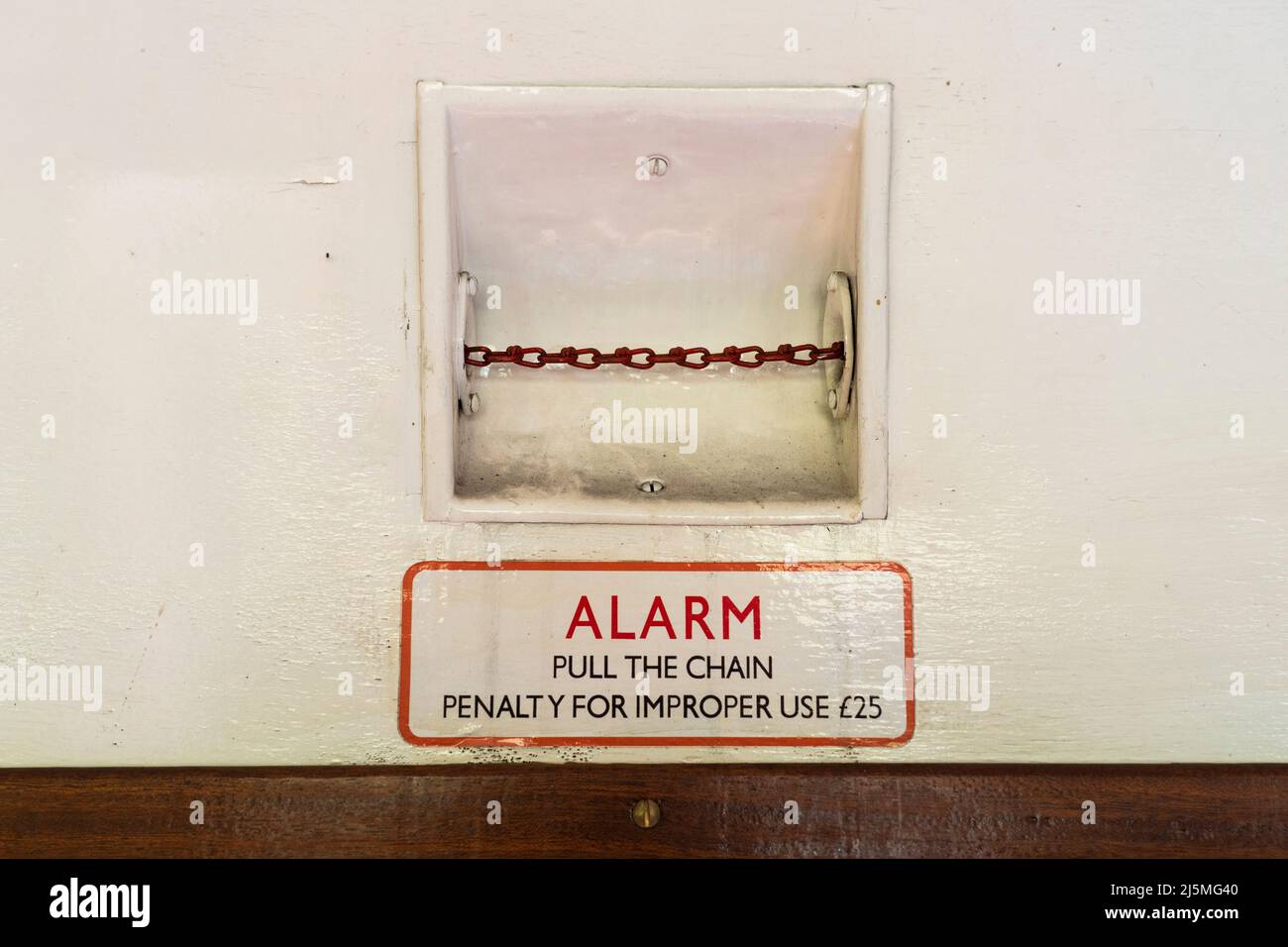 Emergency stop warning notice and pull chain on a heritage carriage on the Alresford to Alton push pull train on the Watercress Line. Hampshire, UK Stock Photo