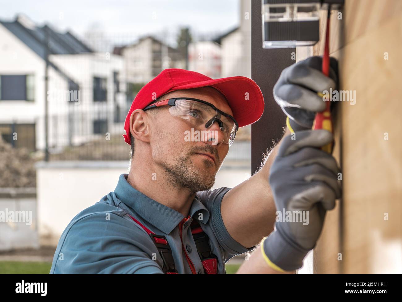 Caucasian Professional Electrician Installing Outdoor Wall Mounted