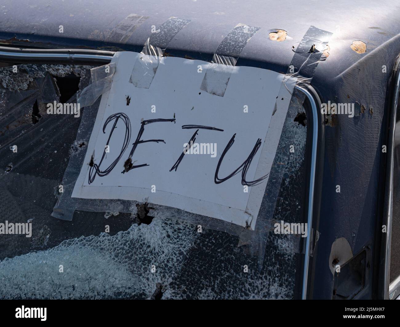 Sign - CHILDREN, close-up on the window of the shot car. Russia's war against Ukraine. Shot cars during the war in Ukraine. Car after being shot with machine guns. Stock Photo