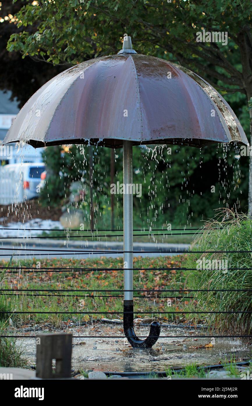 Outdoor art installation of a larger-than-life umbrella catching rainfall, Orleans, Massachusetts, Cape Cod Stock Photo